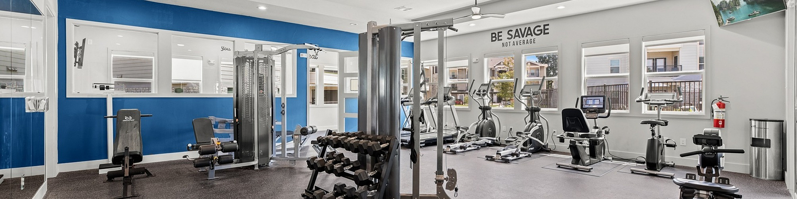 Modern fitness center with sleek design, equipped with state-of-the-art exercise machines and weights, including treadmills, stationary bikes, and rowing machines, offering a bright and motivating environment.
