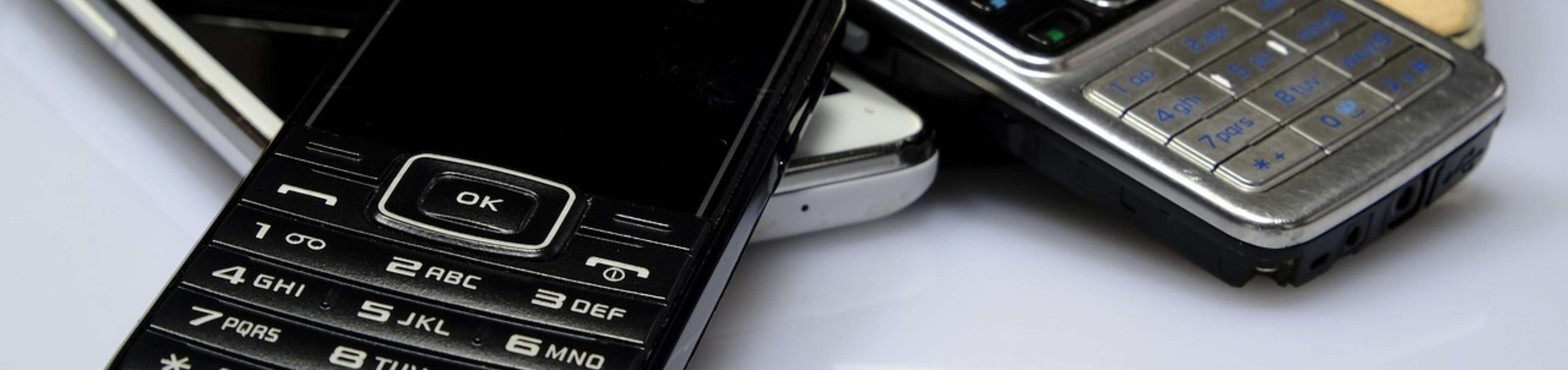 Close-up of a stylish array of classic mobile phones with sleek keypads and metallic finishes.