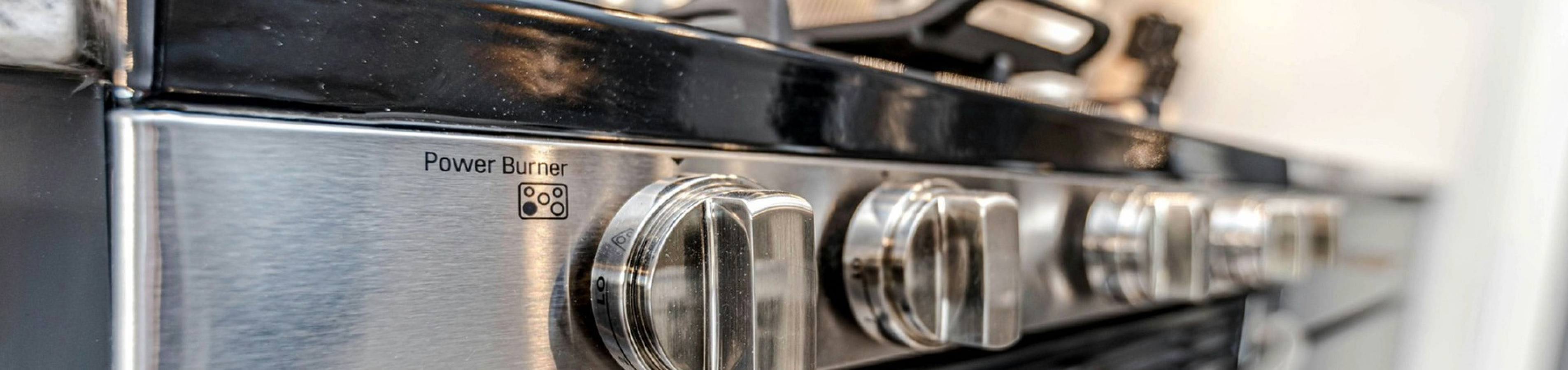 Close-up of a sleek stainless steel stove with modern power burner knobs, perfect for a stylish kitchen upgrade.