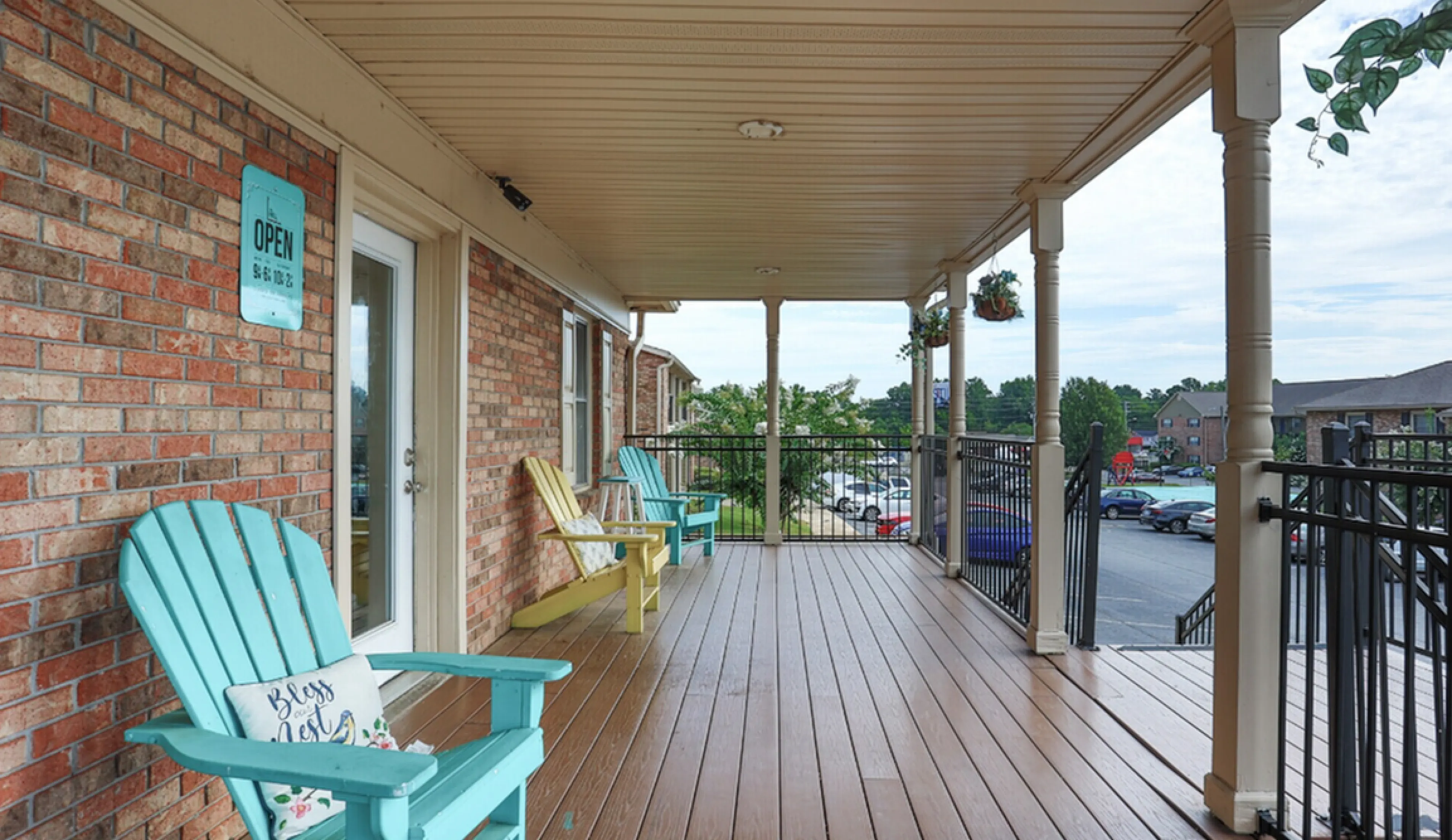 Charming outdoor porch with colorful Adirondack chairs and scenic views, perfect for relaxing afternoons.