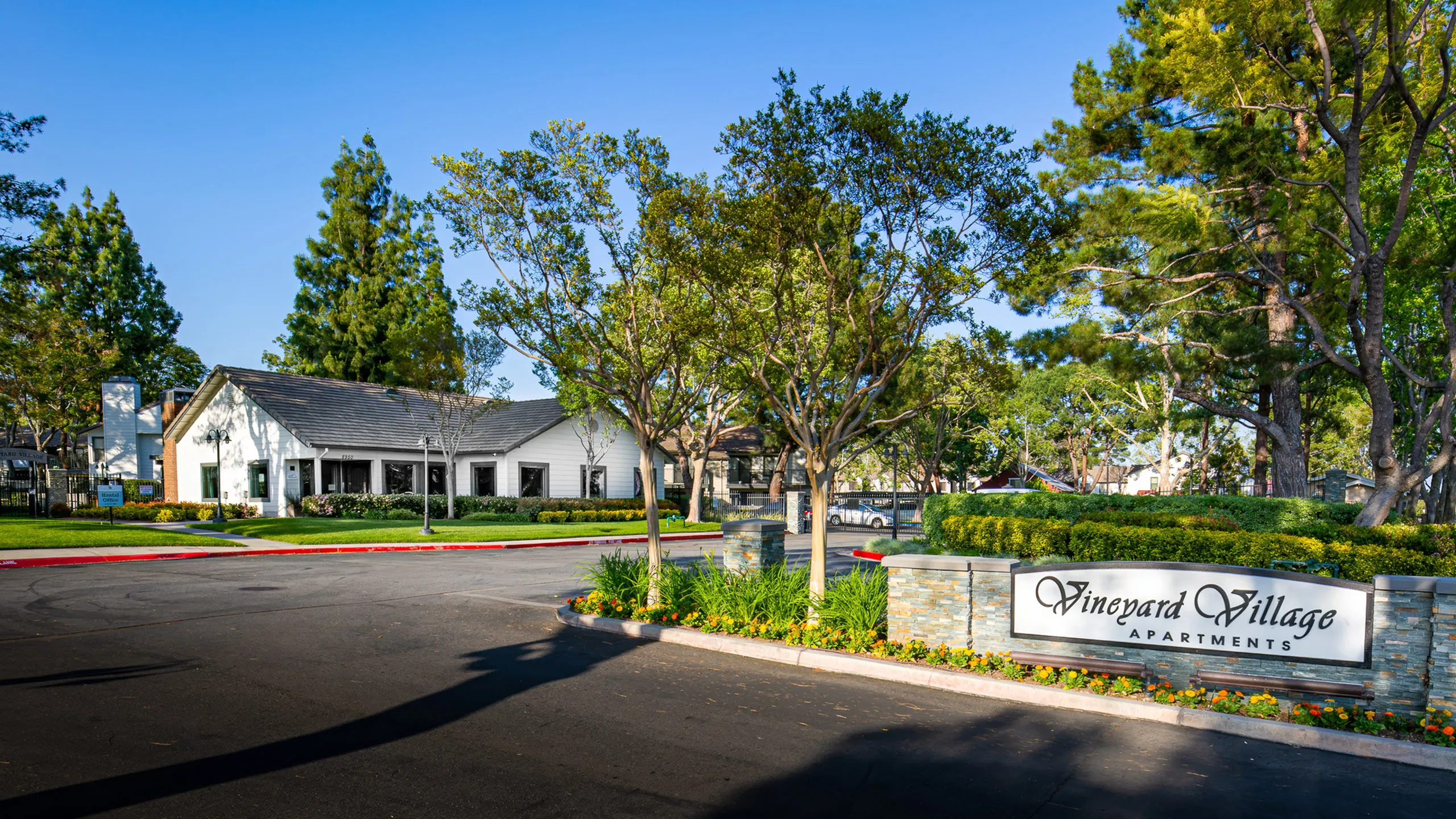 View of property entrance, sign and building in background.