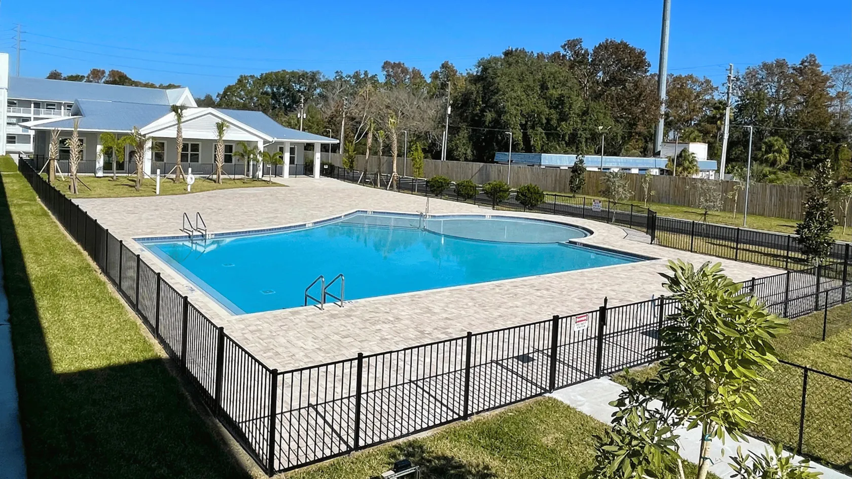 Inviting outdoor pool area with a spacious deck, surrounded by lush greenery, ideal for relaxation and family gatherings.