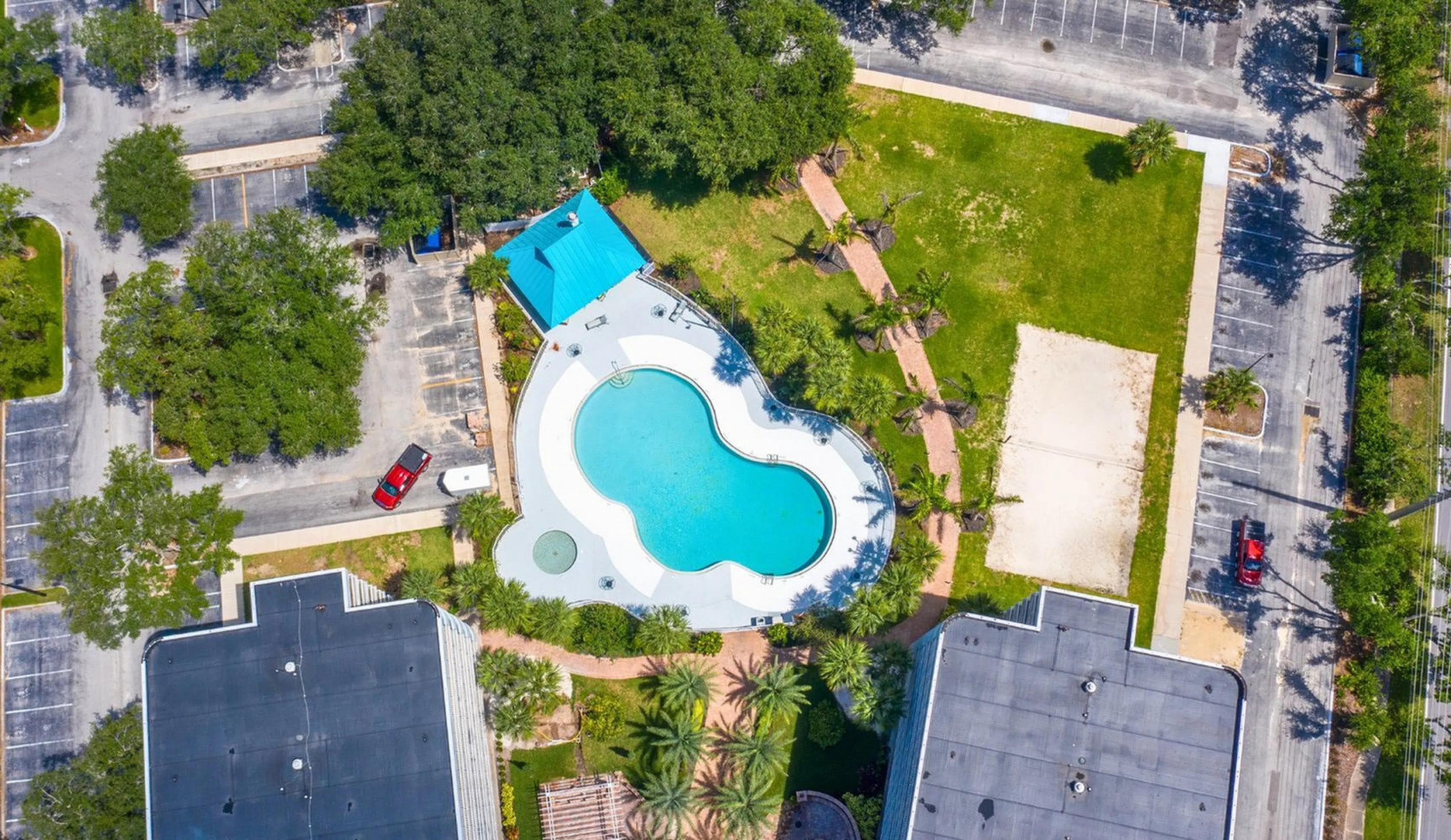 Beautiful aerial view of a private pool oasis surrounded by lush greenery and modern architecture, showcasing a perfect blend of luxury and nature.