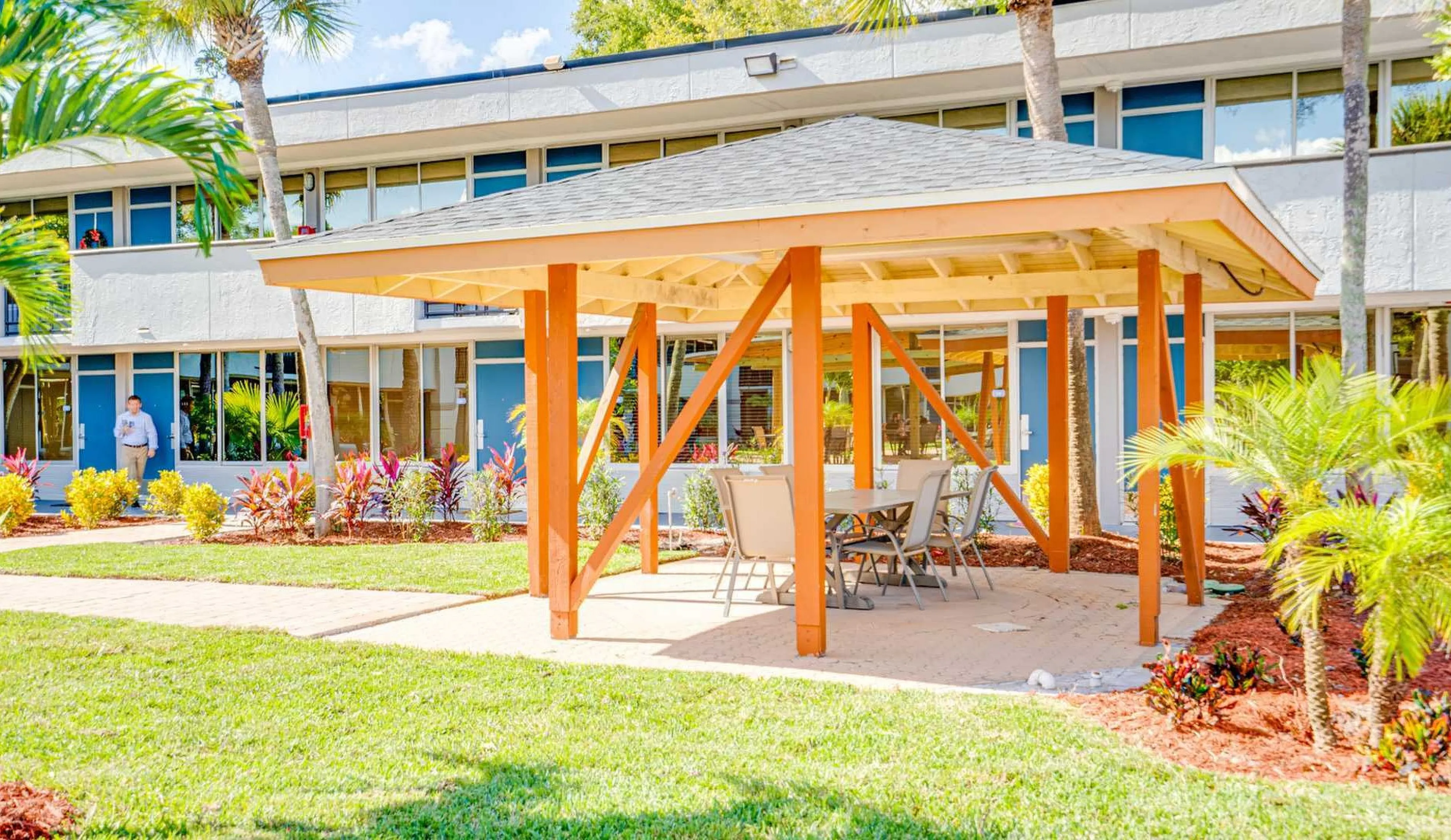 Charming outdoor gazebo set in a lush garden, offering a relaxing seating area for gatherings in a vibrant apartment community.