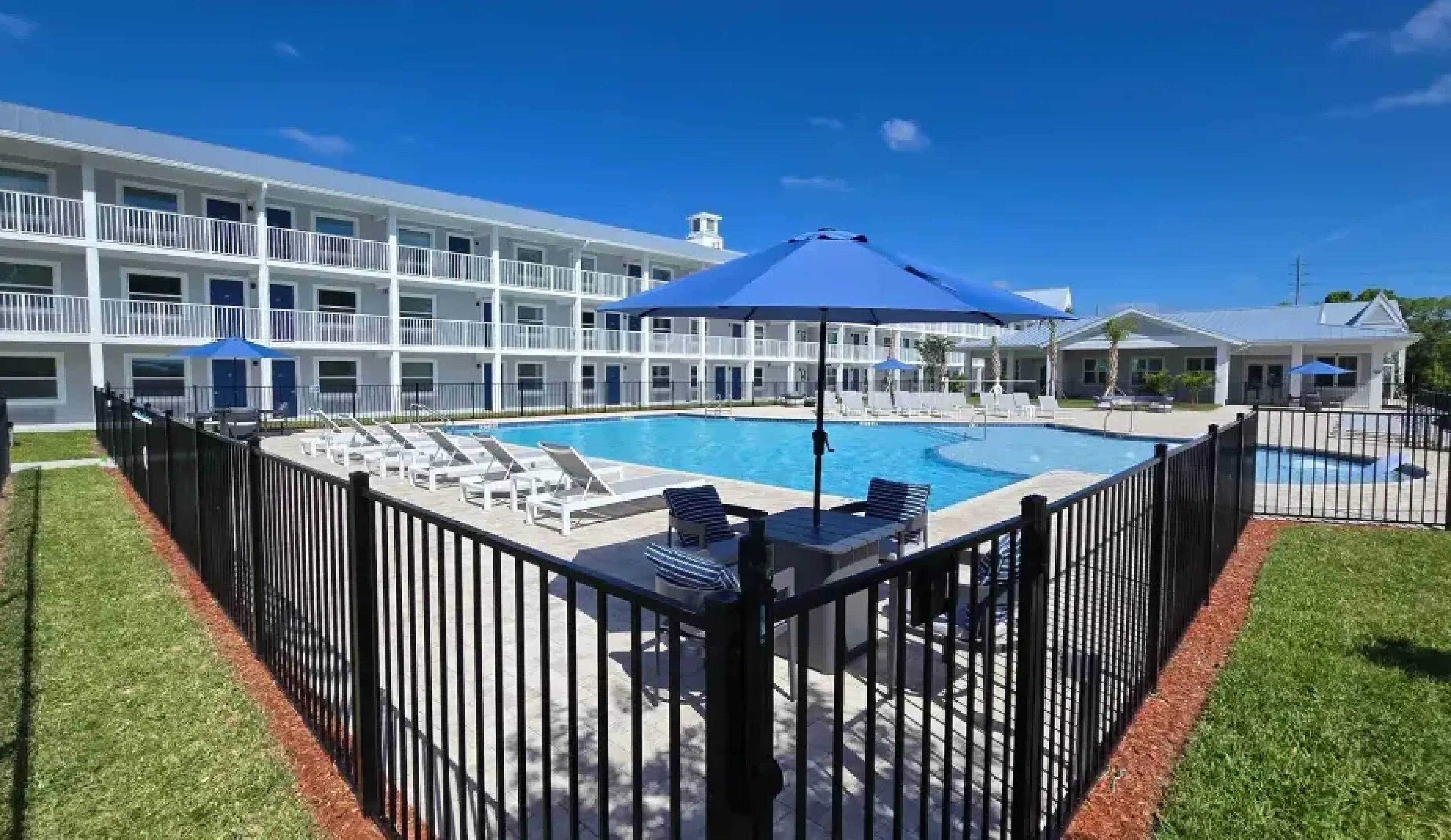 Elegant apartment complex in Kissimmee, Florida showcasing modern architecture with spacious balconies and palm-lined parking area.