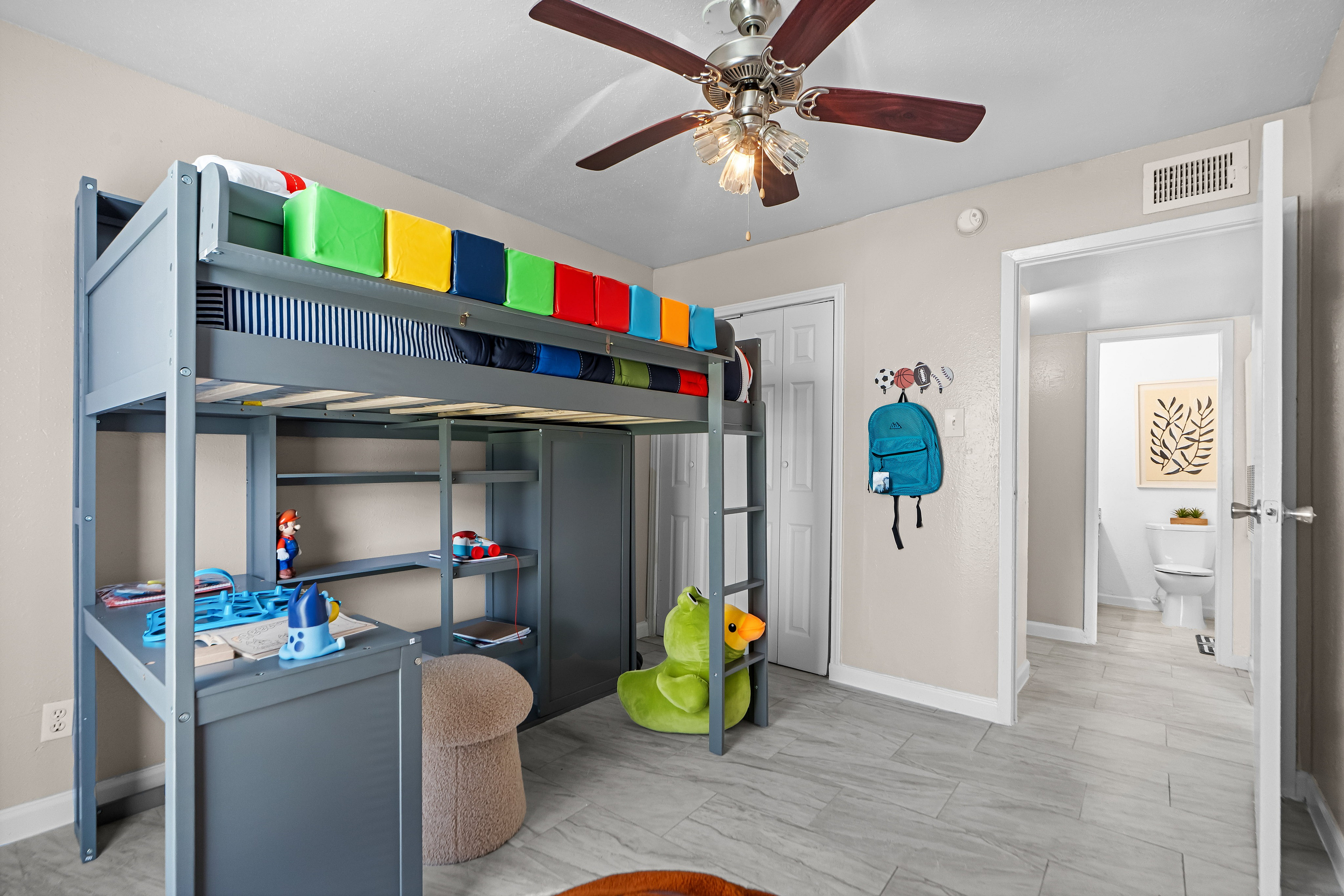 Charming kids' room with a colorful loft bed, playful decor, and ample storage space.