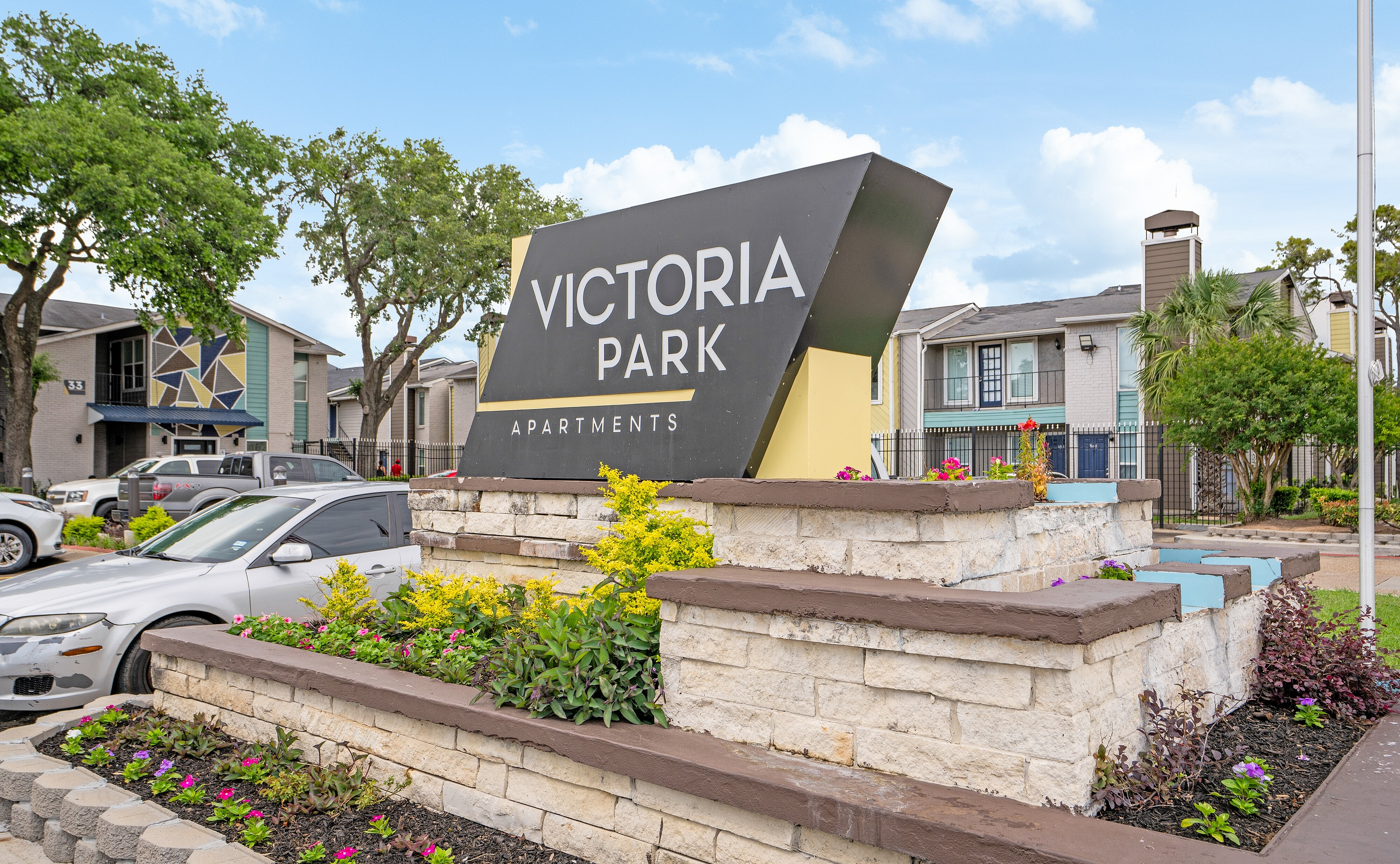 Welcoming exterior of Victoria Park Apartments with vibrant landscaping and modern architecture, nestled in a serene environment.