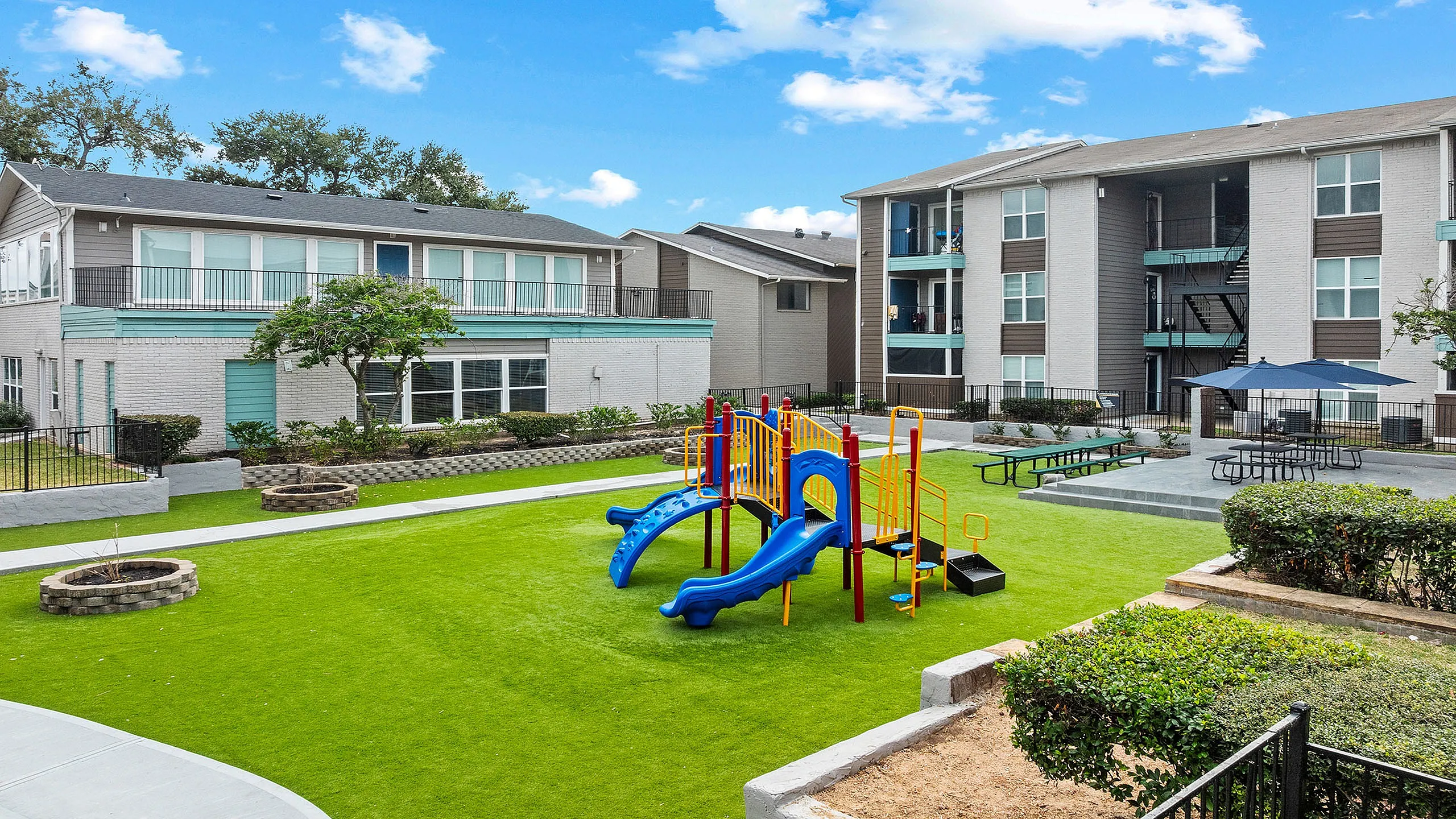 Charming apartment complex with vibrant children's playground and lush landscaped gardens, perfect for family living.