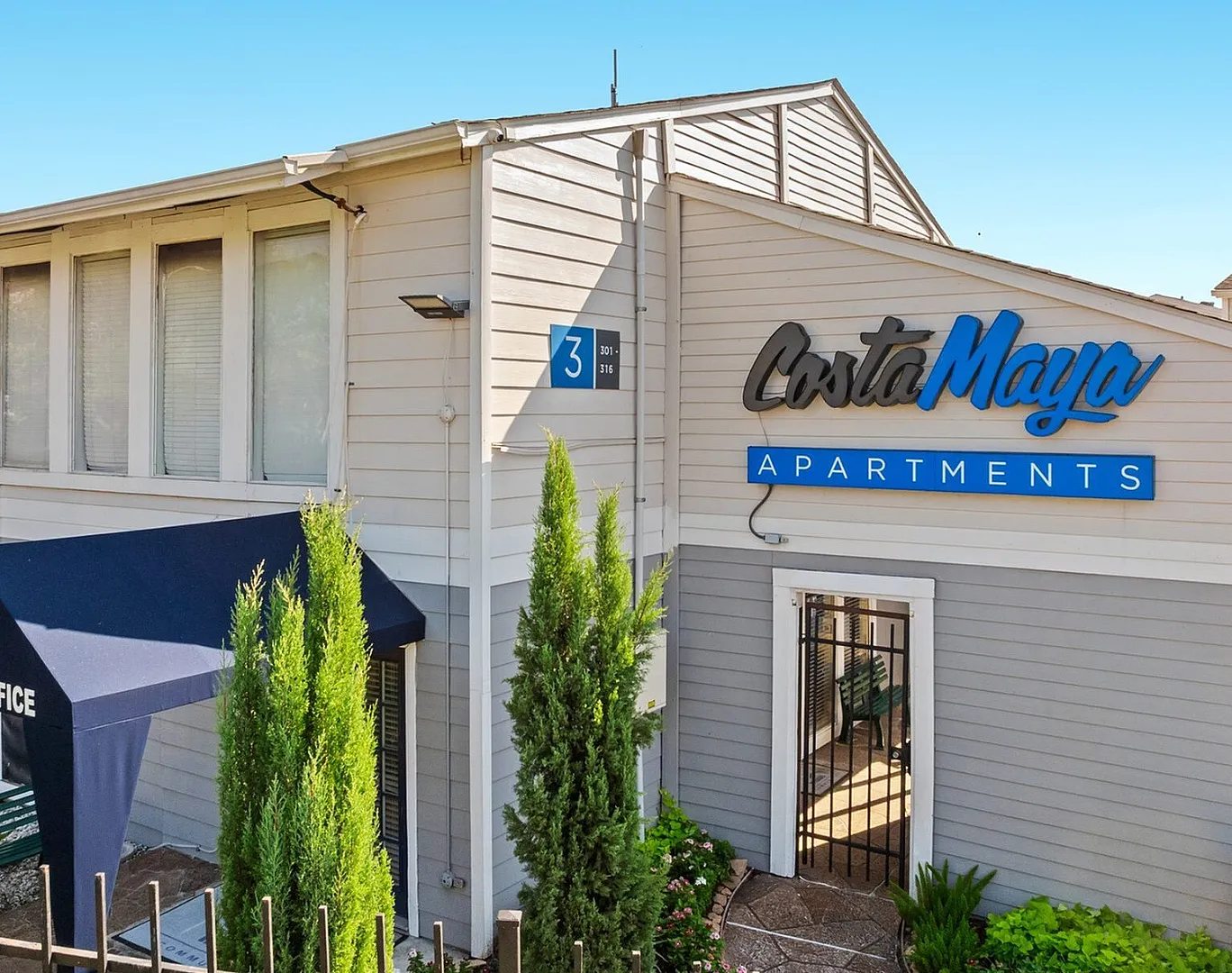 Inviting entrance of Costa Maya Apartments with stylish signage, lush greenery, and welcoming ambiance.
