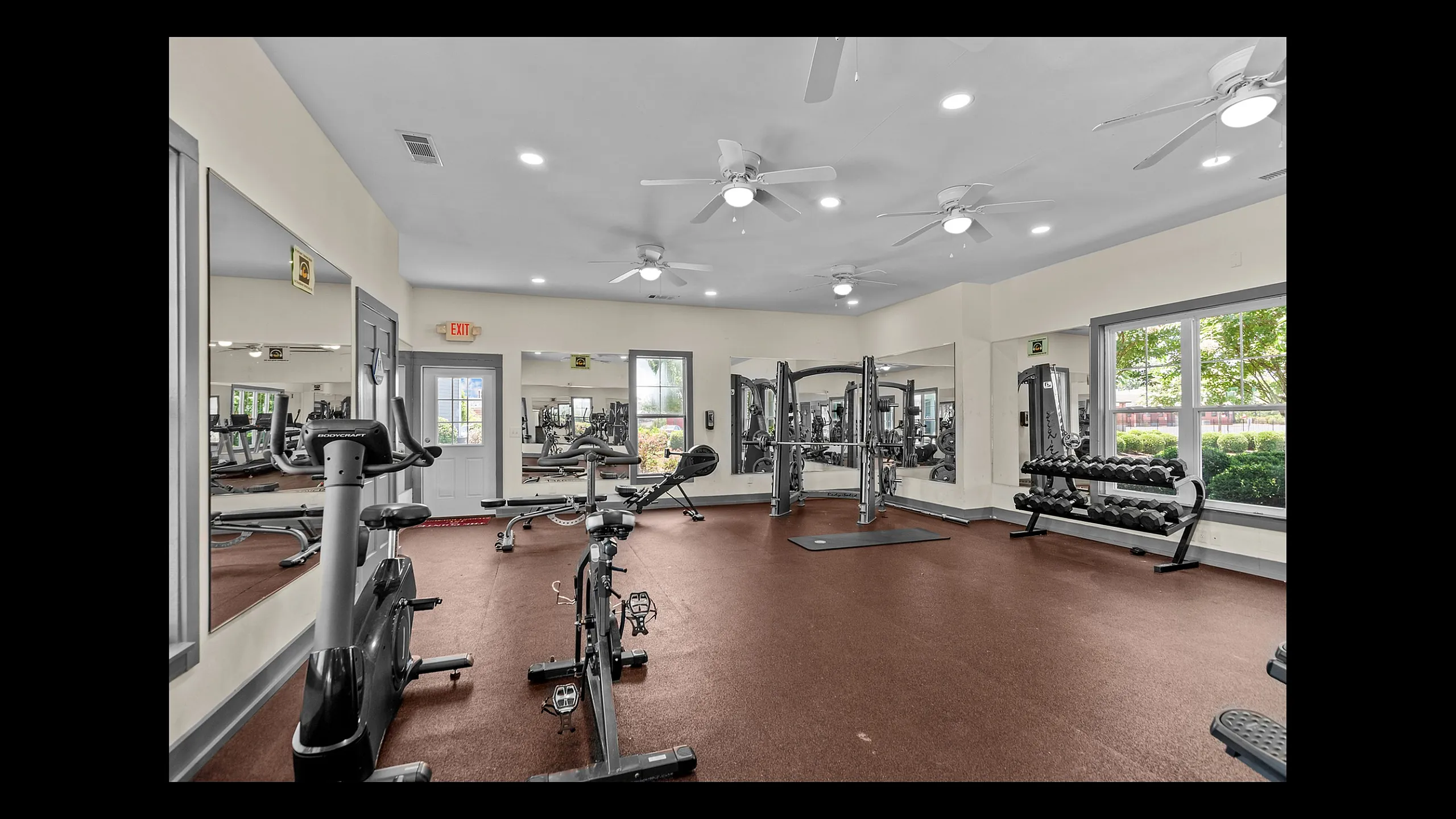 Bright and modern fitness center with state-of-the-art equipment and large windows offering natural light.