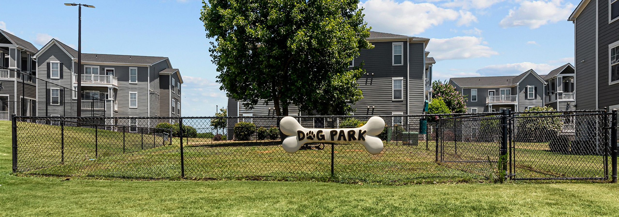 Inviting apartment complex with expansive green spaces and a dedicated dog park for residents.