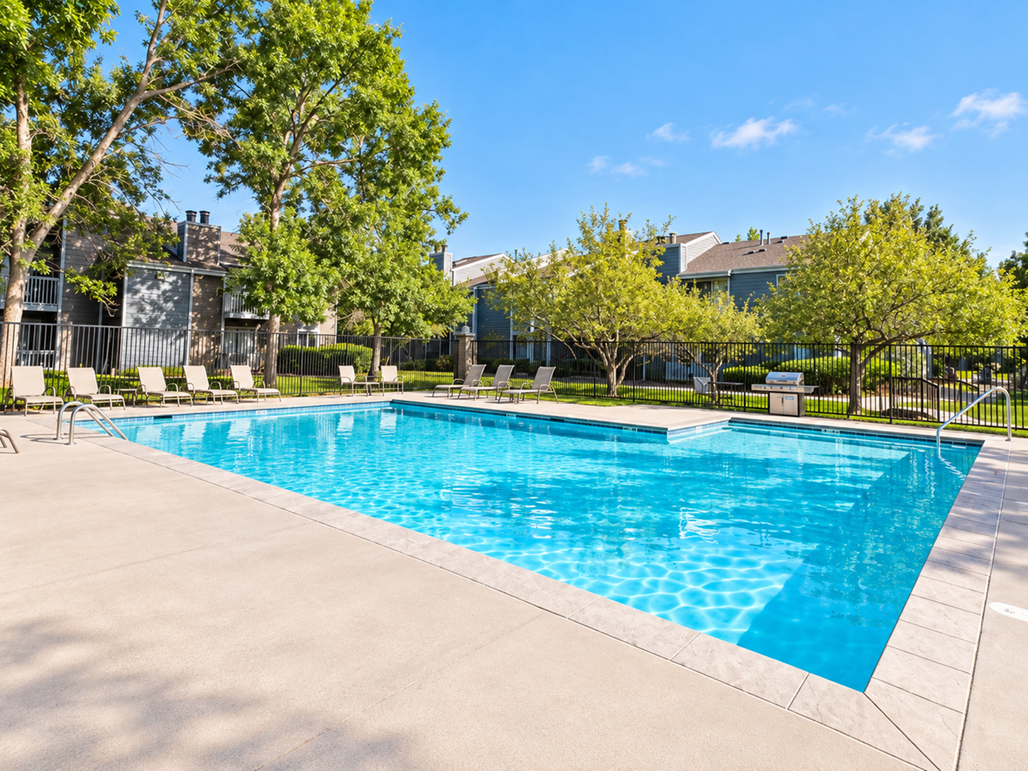 Inviting outdoor pool surrounded by lush greenery and lounging chairs, perfect for relaxation and enjoying sunny days.
