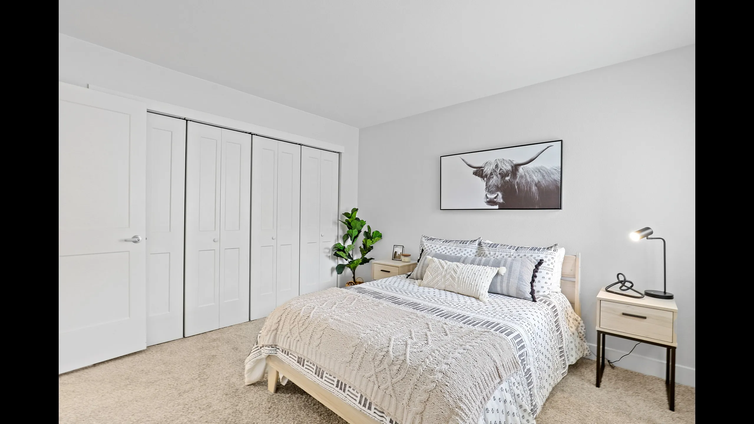 Bright, cozy bedroom with elegant decor featuring a large bed, stylish artwork, and modern furnishings in a serene and inviting space.