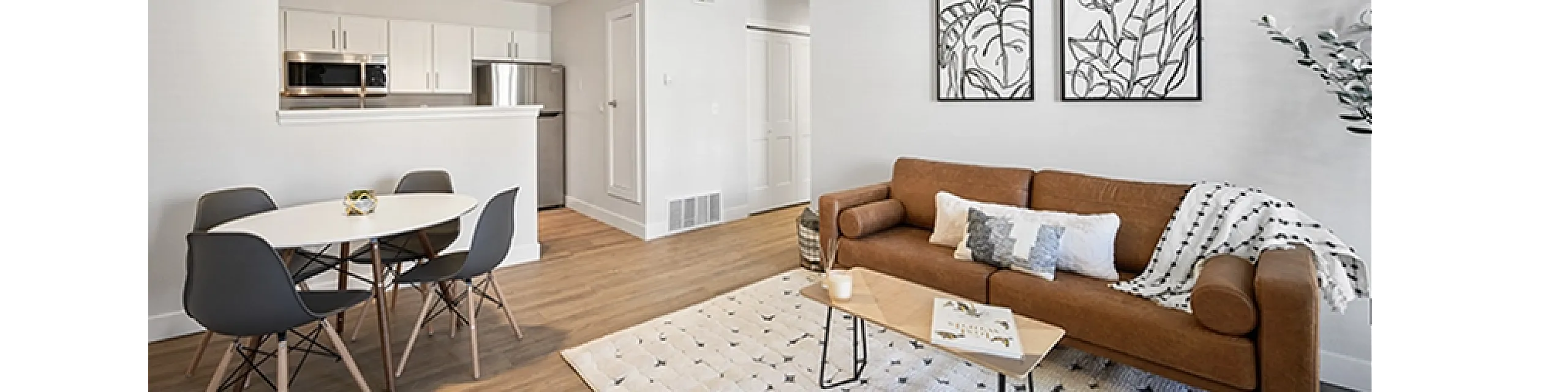 Modern open-concept living area with a cozy brown sofa, chic dining set, and sleek contemporary kitchen.