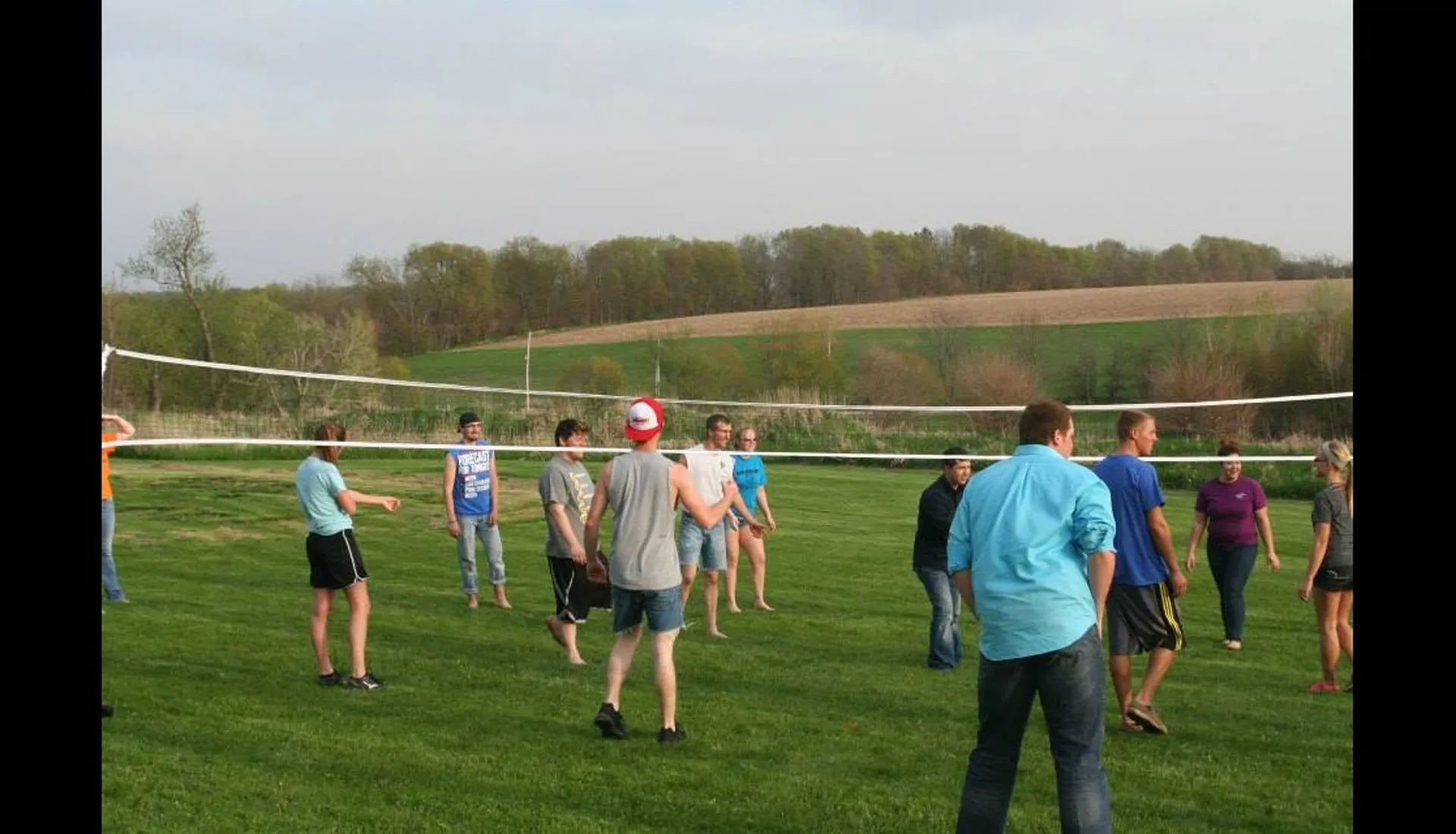 Kids playing volleyball on the grassy back hill at Prairie Pointe Apartments