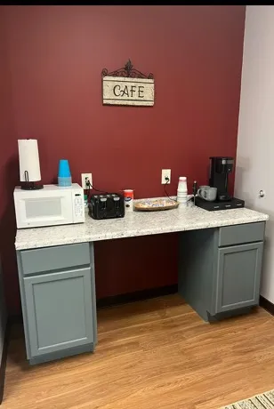 coffee bar set up with cabinets a counter and microwave