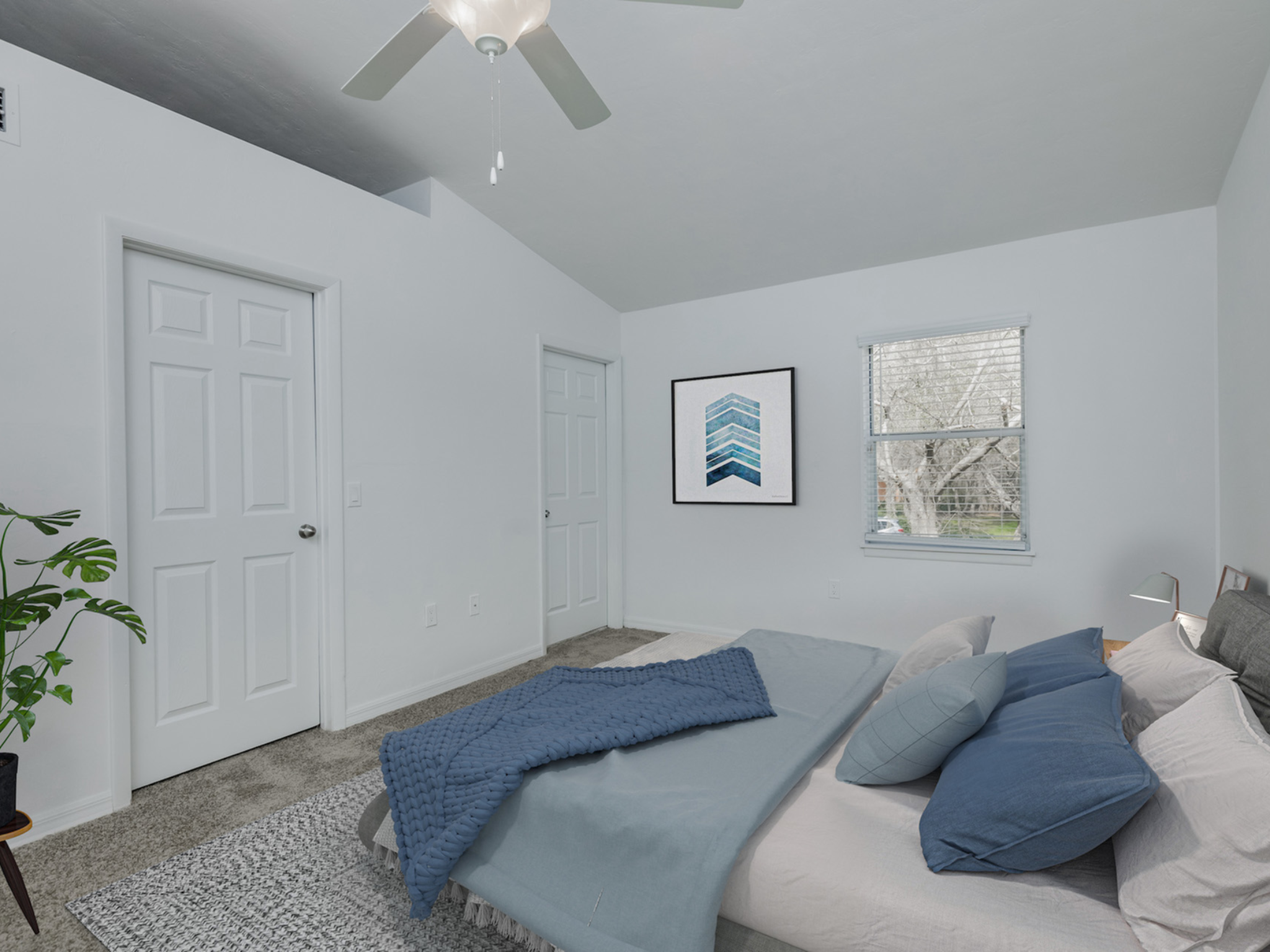Master bedroom with ceiling fan, window, furniture.