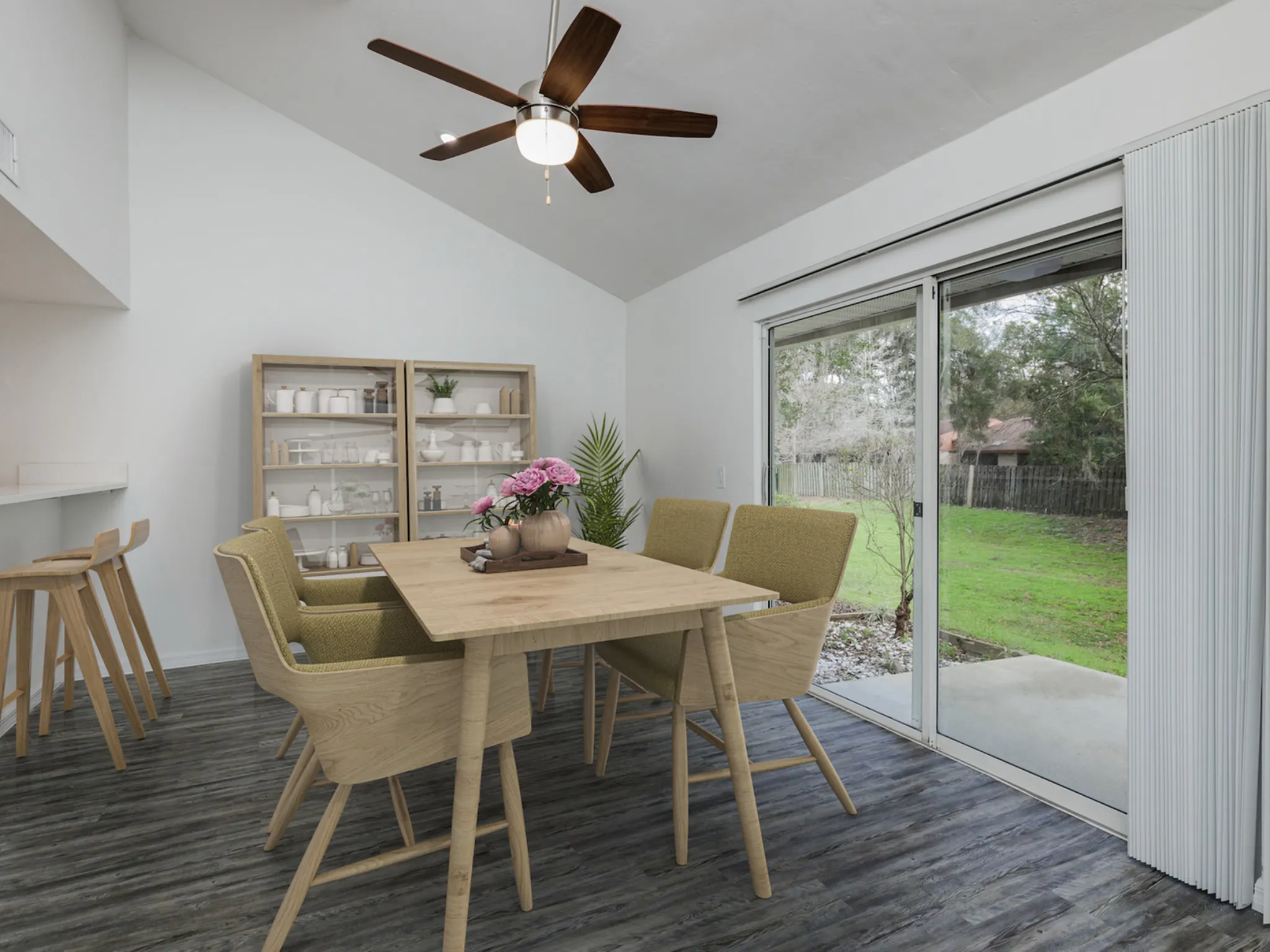 Dining area with table, chairs, sliding glass door and ceiling fan.