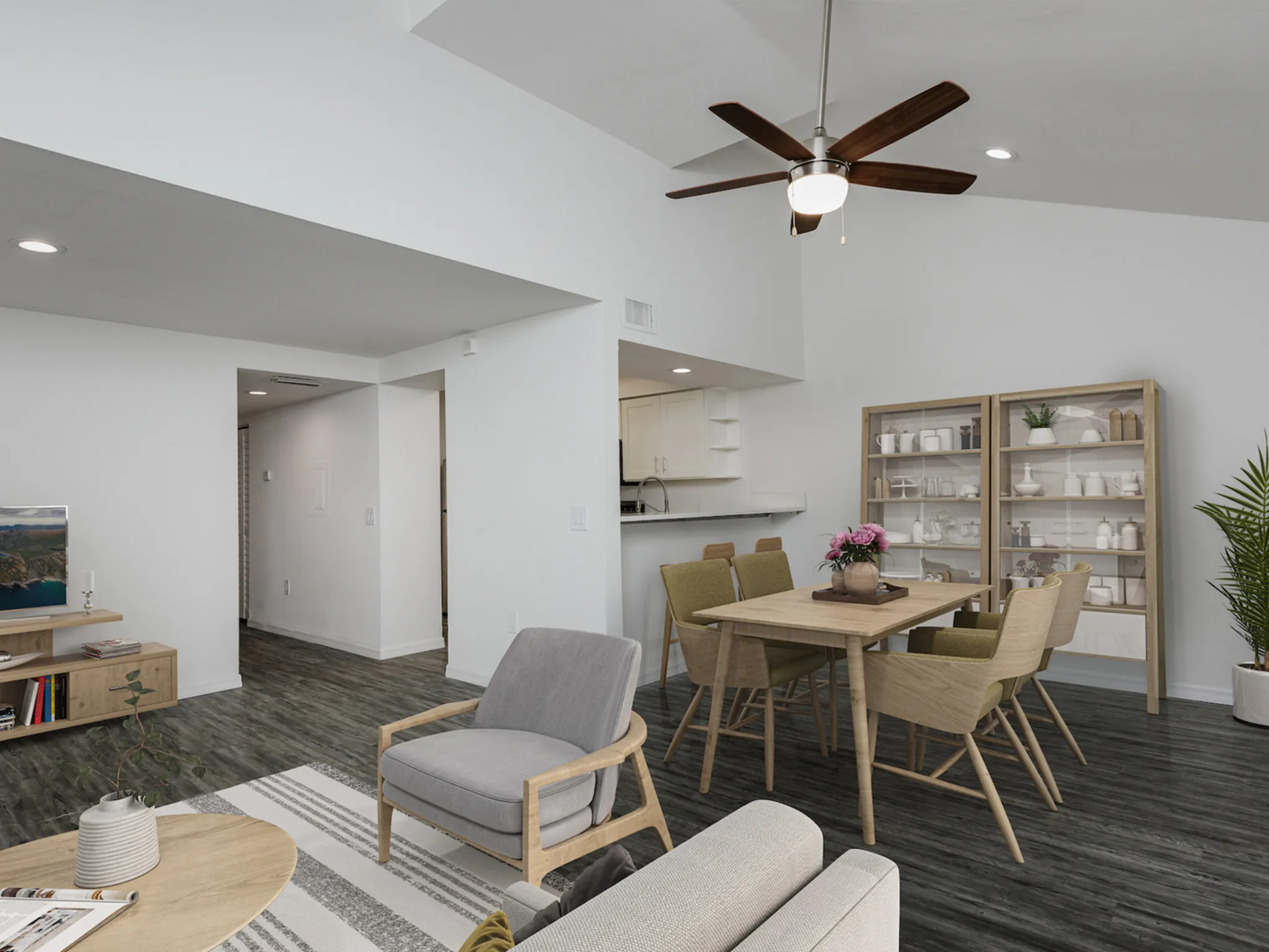 3 Bedroom - Living and dining area with table, chairs, shelves, ceiling fan hanging from vaulted ceiling.