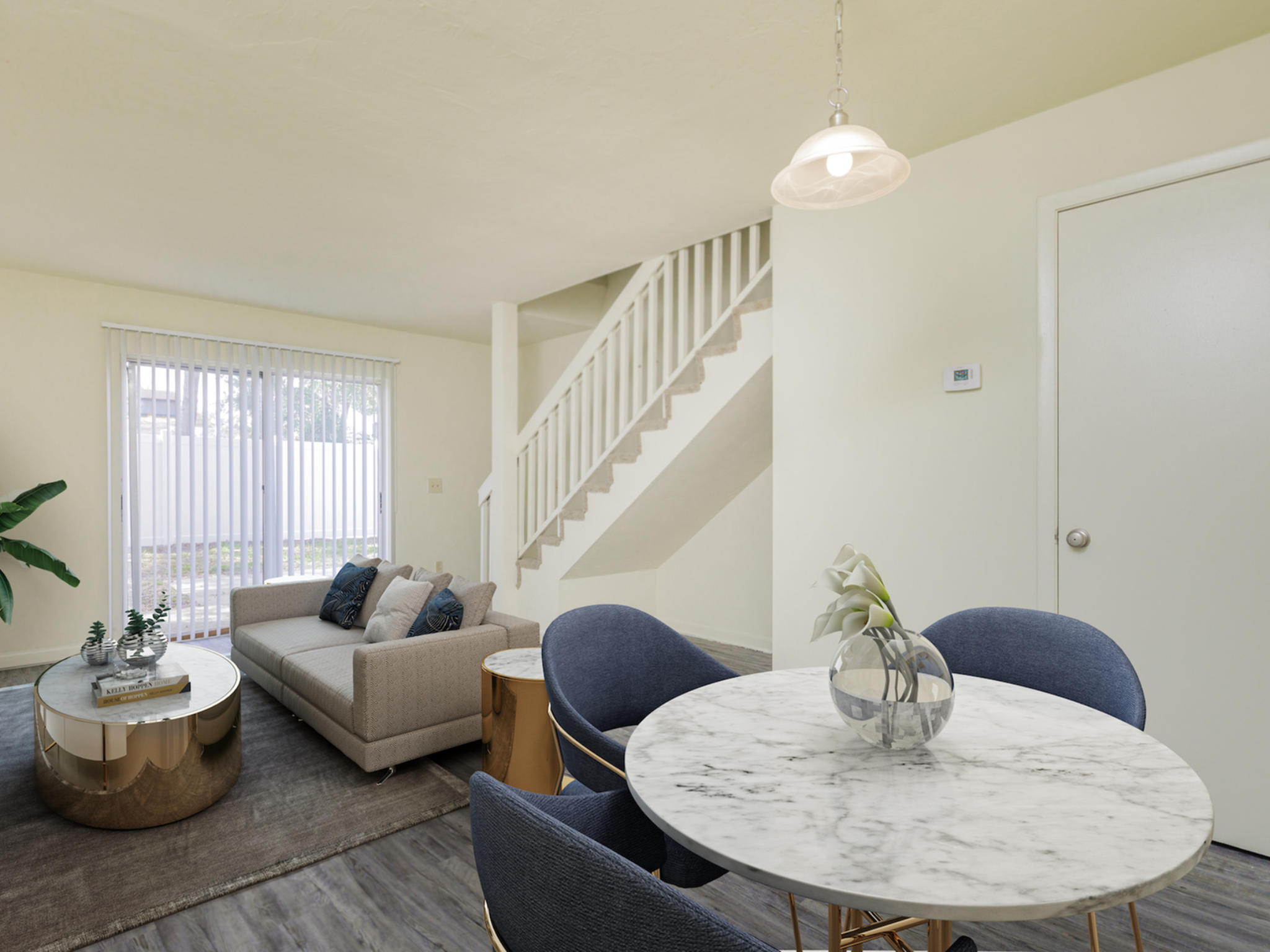 Living and dining area with sliding glass doors and stairs going up to second floor.