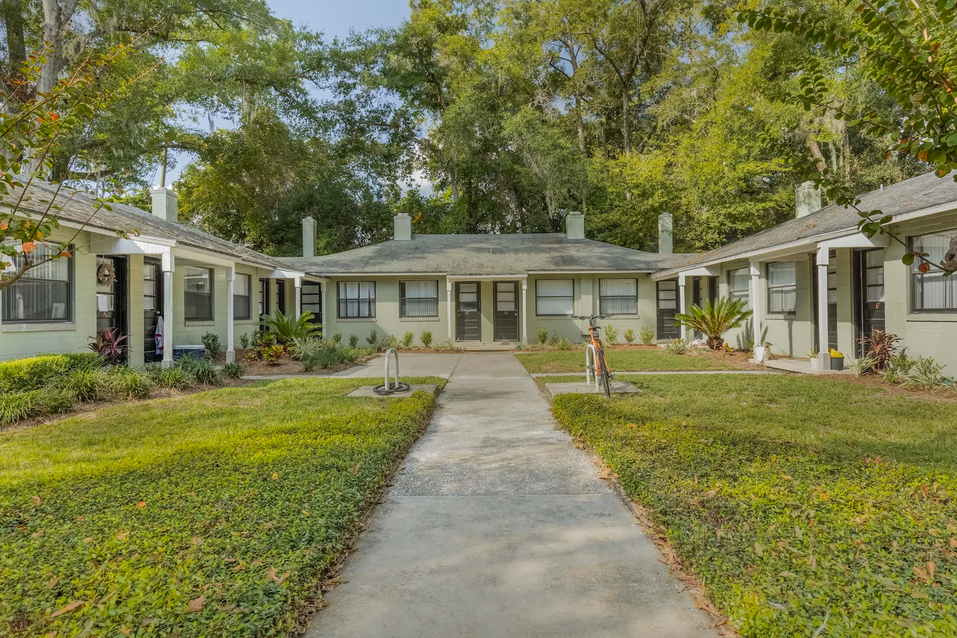 Exterior of the 1 story Chapman Building. There is a sidewalk that leads up to each entrance surrounded by green grass.