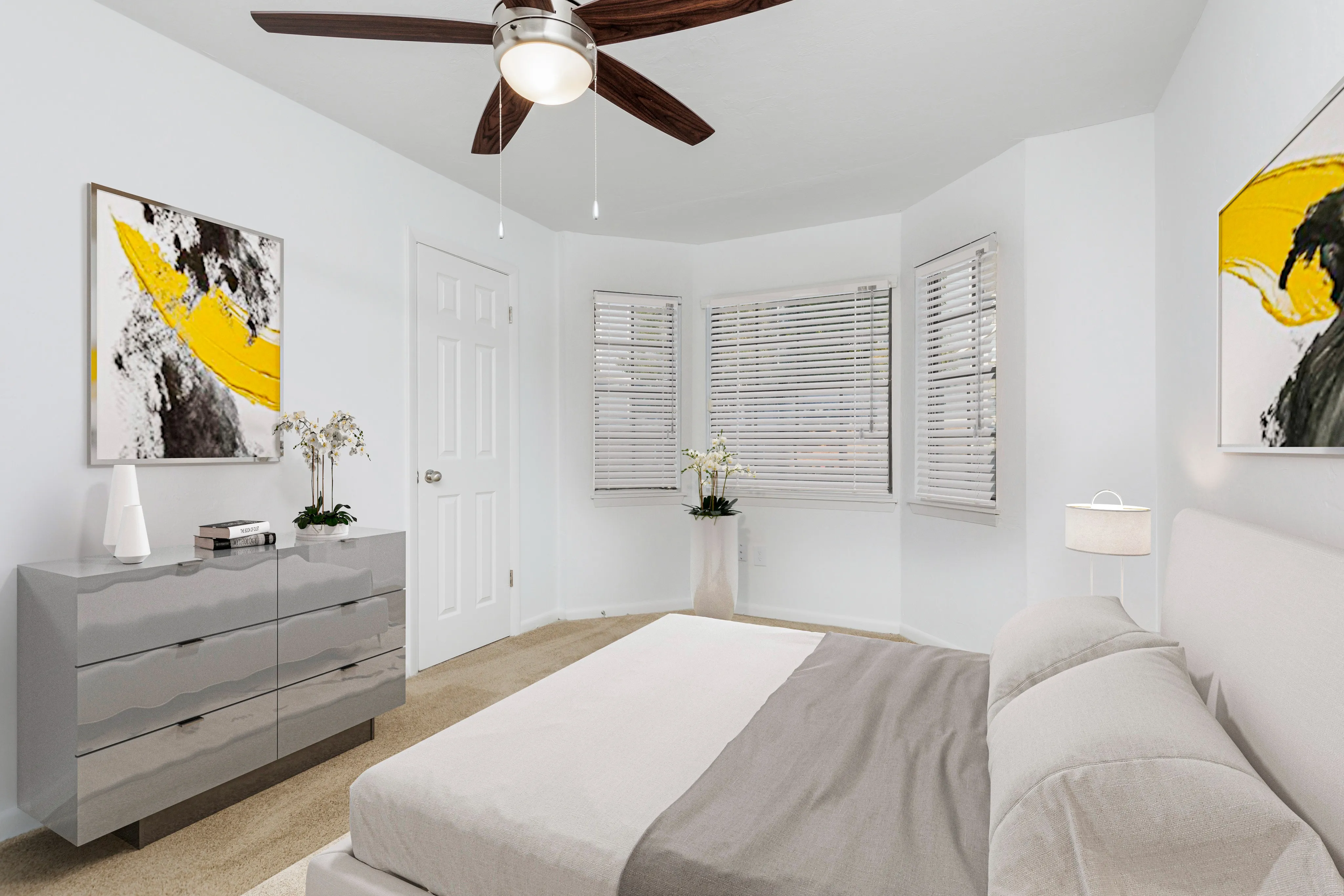Bedroom with bay window, bed, ceiling fan, night stand.