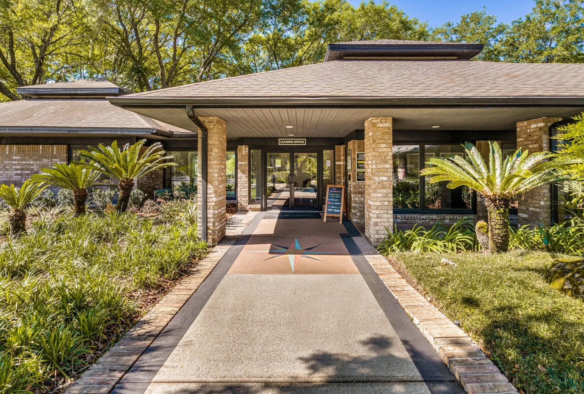 Leasing office entrance with palm trees surrounding it,