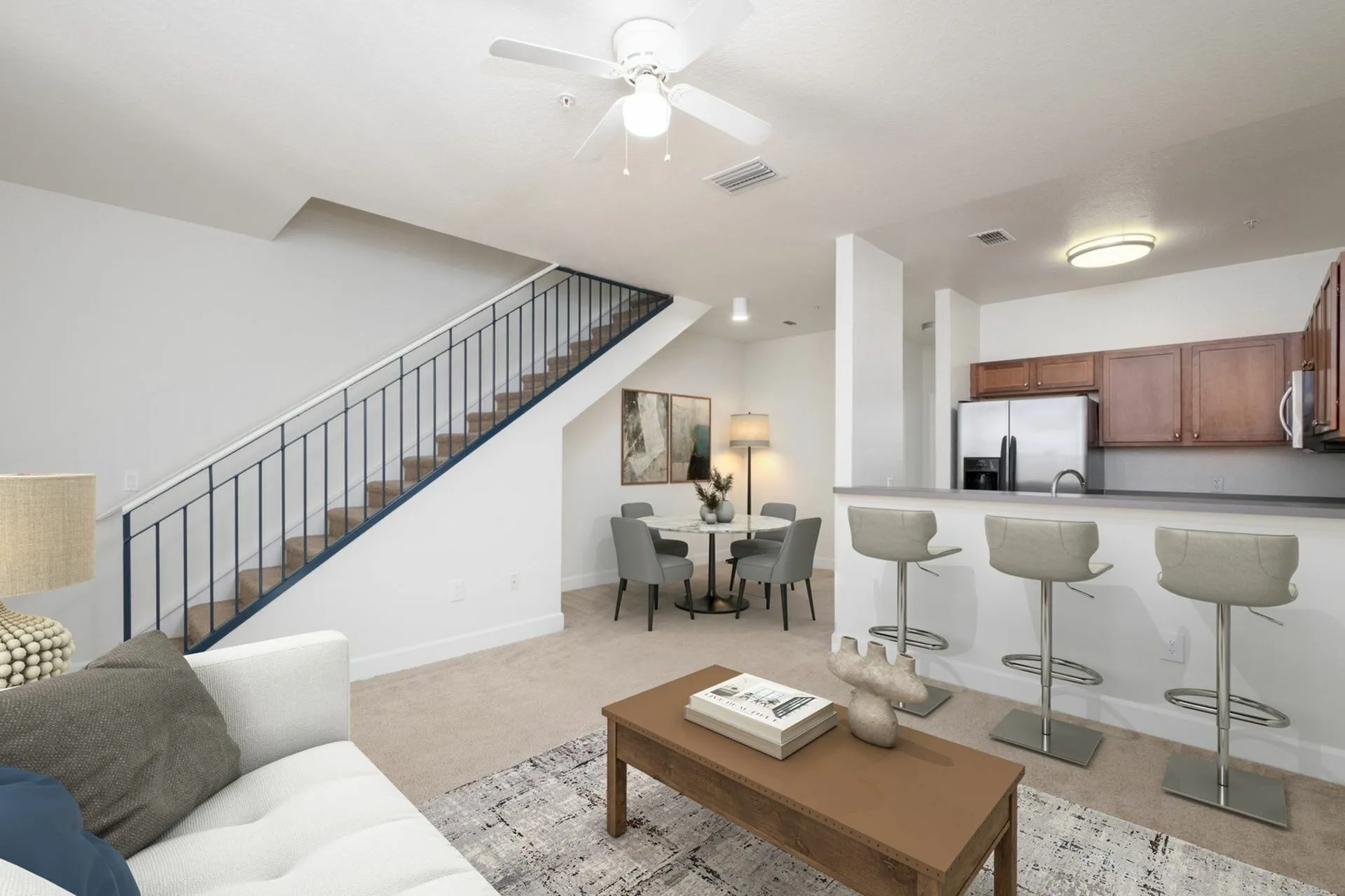 Living room and kitchen with bar stools, dining table, and upstairs