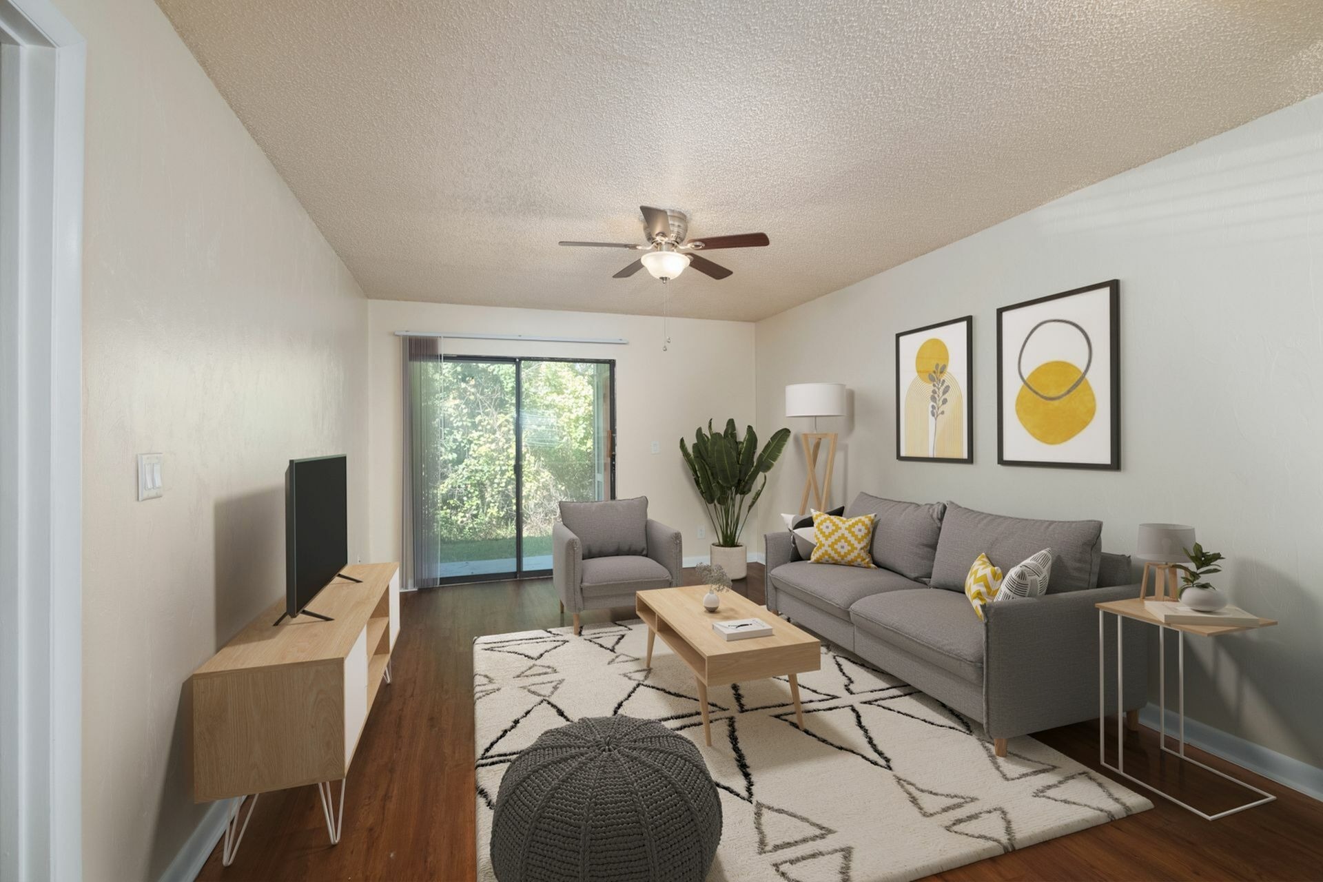 Living room with gray couch, tv, and sliding glass door