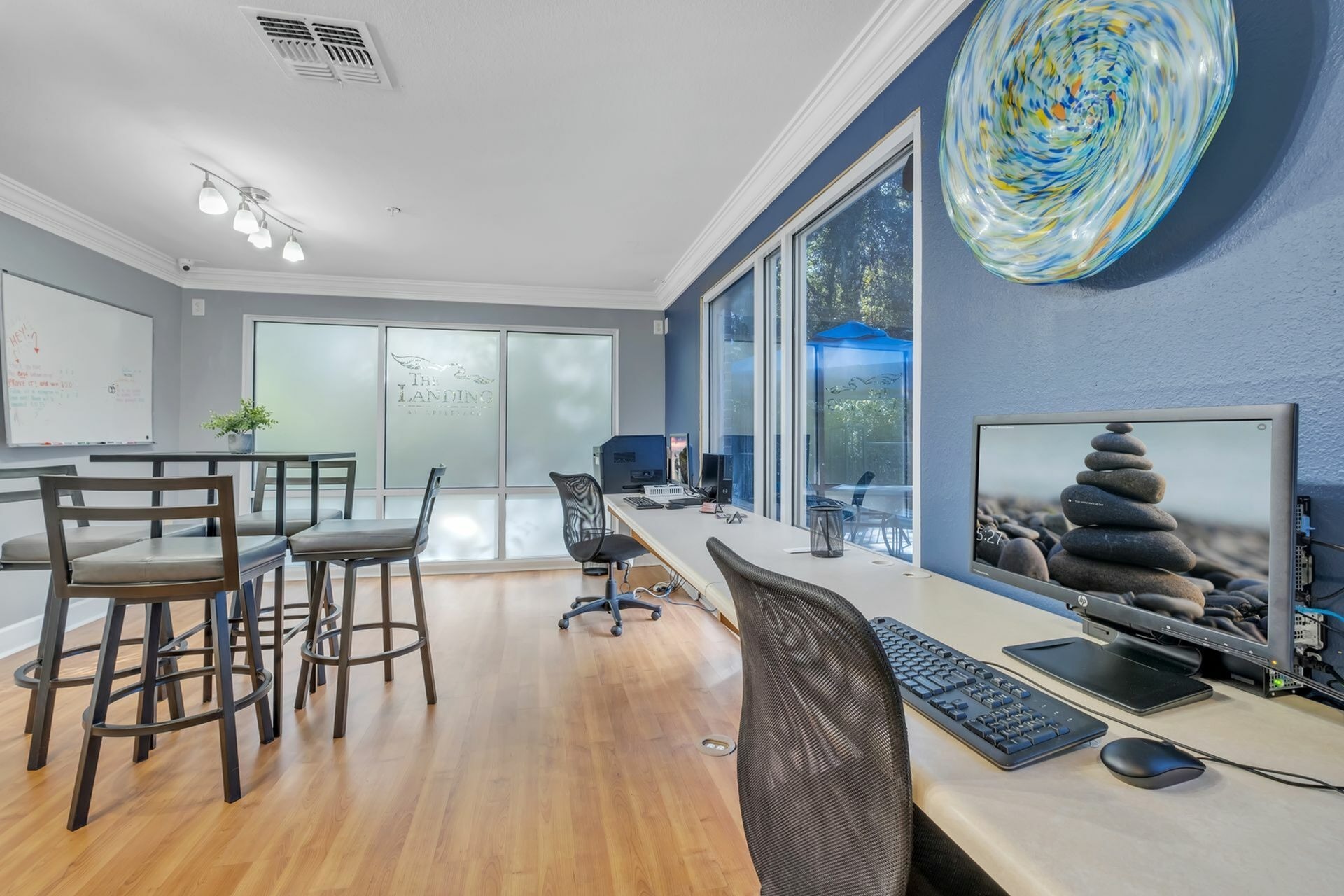 Community computer lab with hardwood floors, computers, and a blue wall.