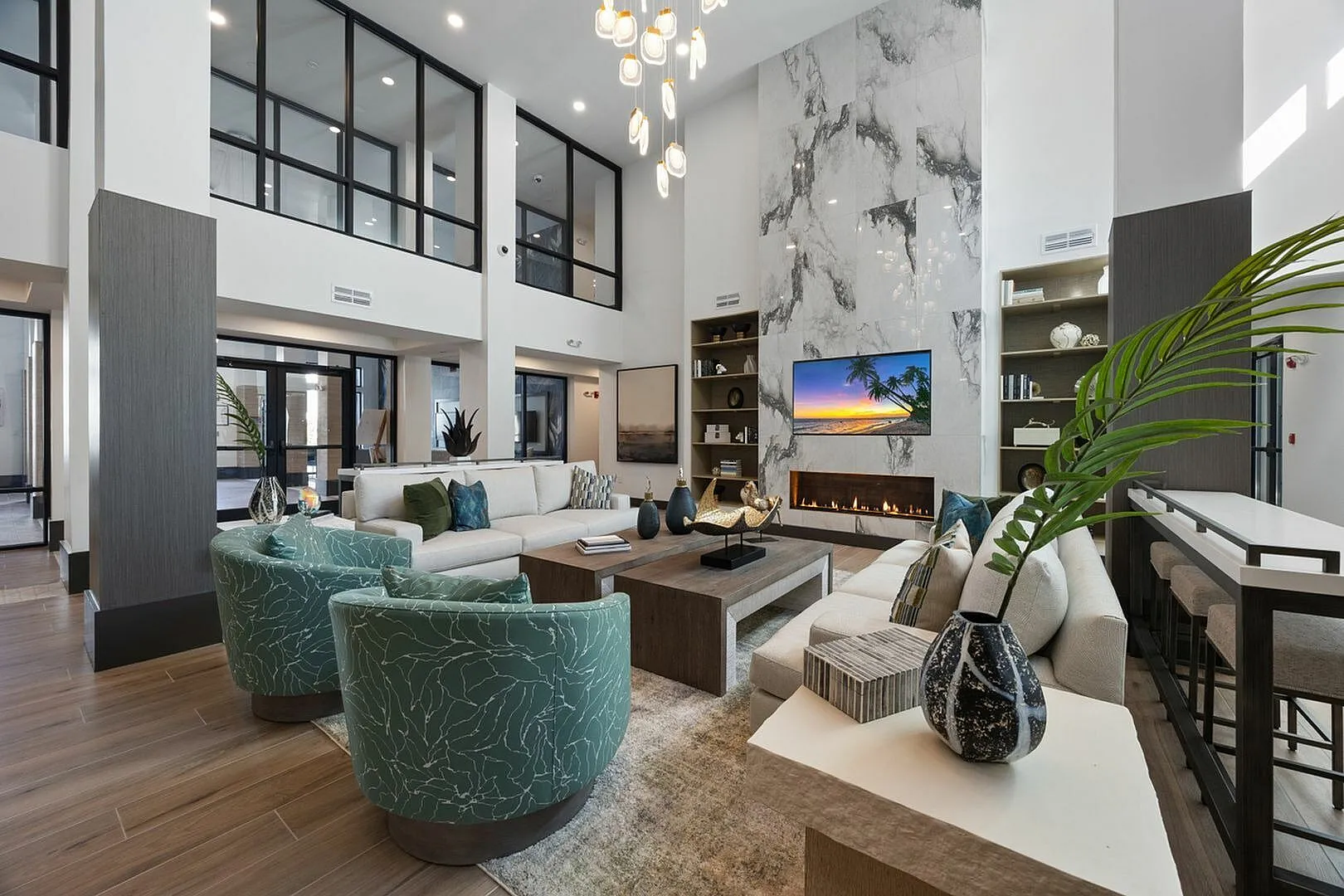 Luxurious modern clubhouse with high ceilings, stylish furniture, and a marble fireplace.