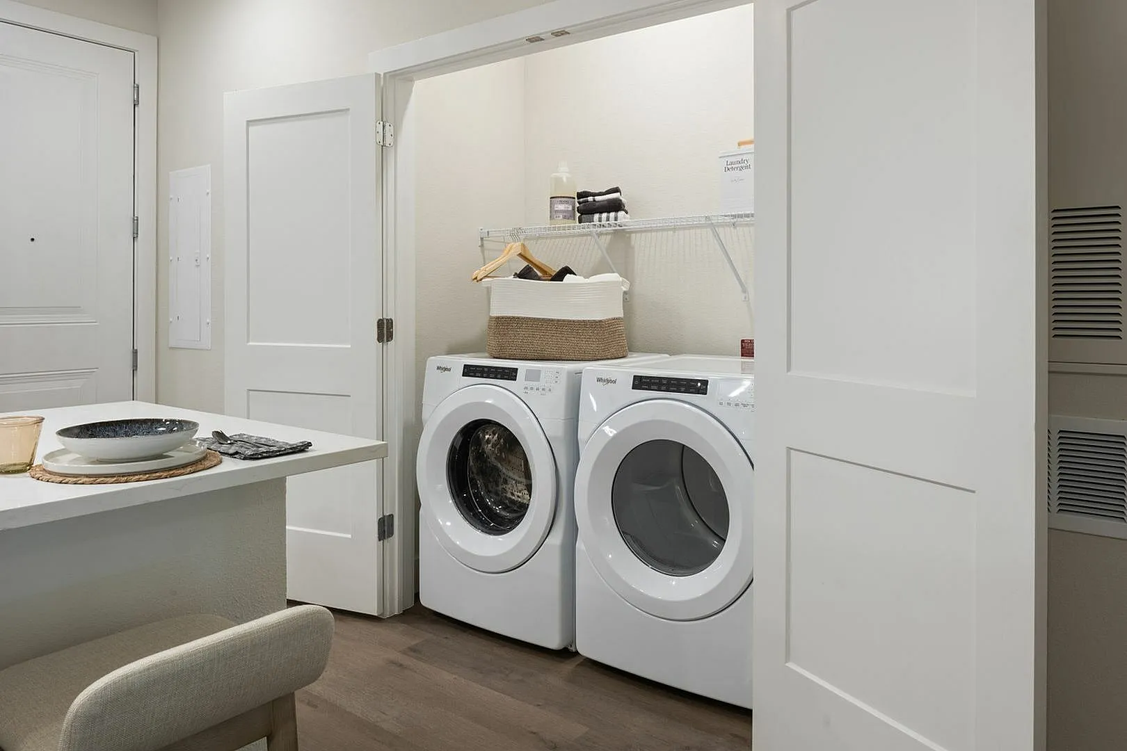 Contemporary laundry area with a stylish washer and dryer setup next to a cozy dining space.