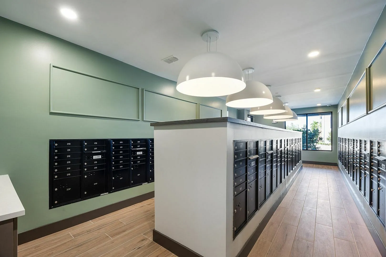Modern apartment mailroom with stylish lighting and organized mailboxes.