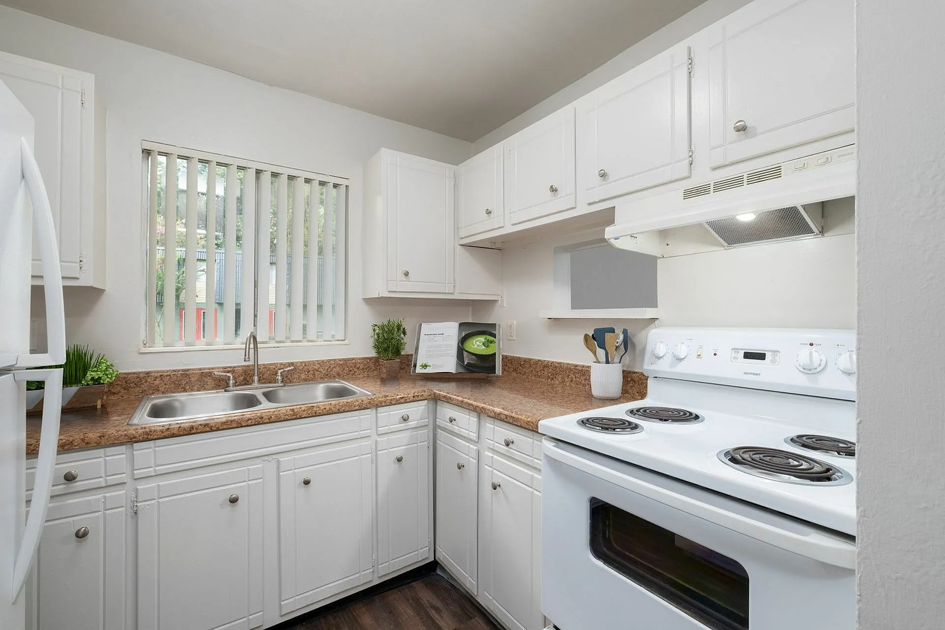Sleek kitchen with white cabinetry, modern appliances, and elegant countertops, inviting a bright and airy atmosphere.