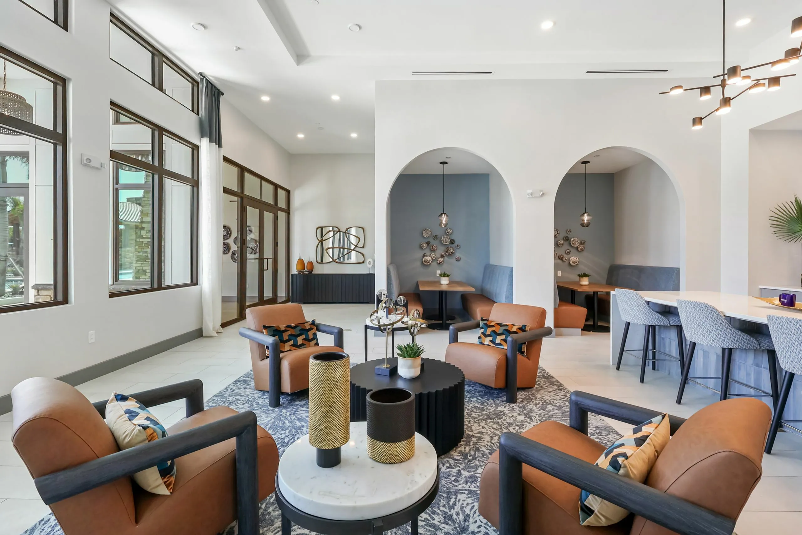 Luxurious open-concept lounge area with modern seating, stylish decor, and expansive windows inviting warm natural light.