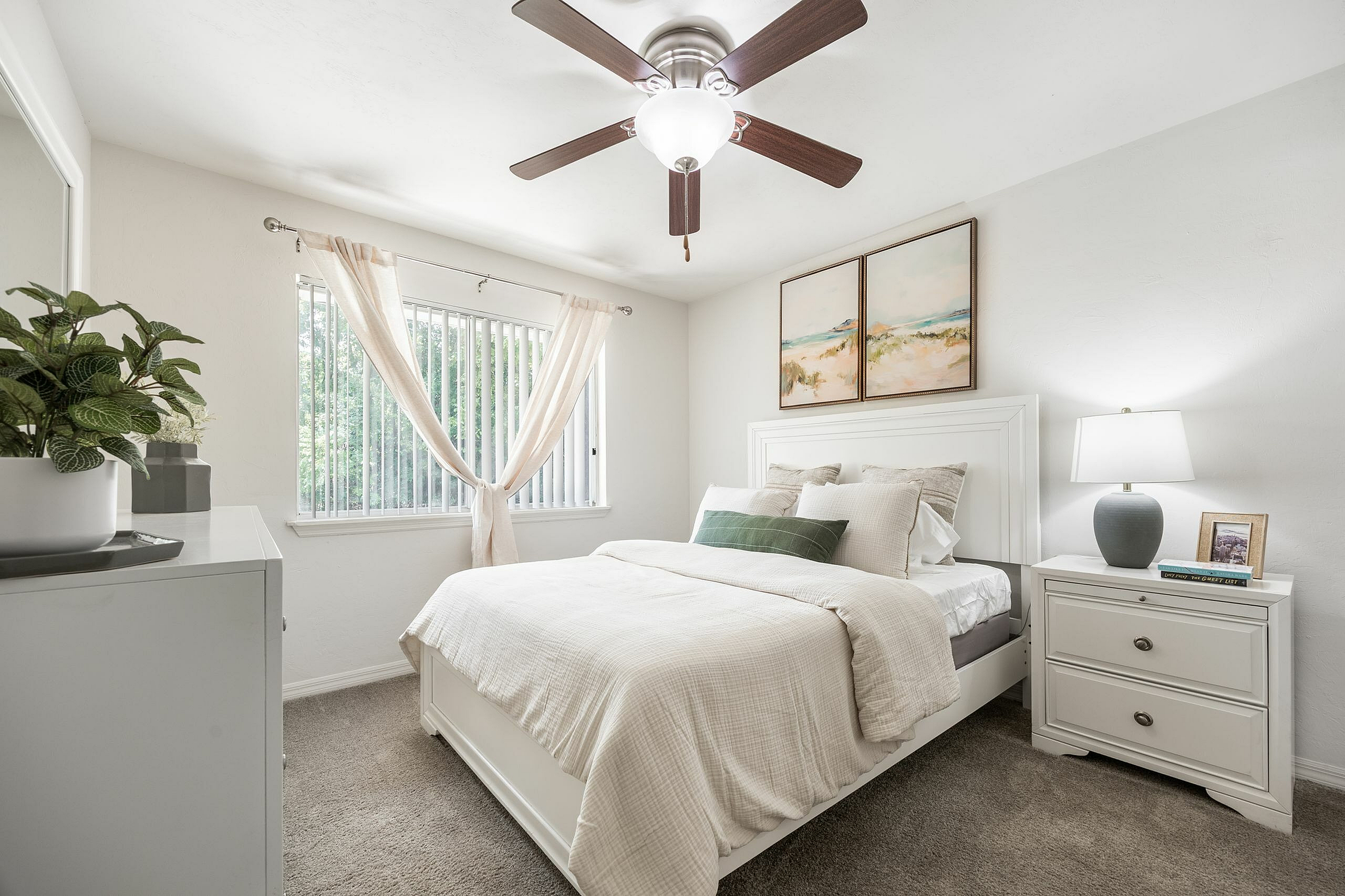 Inviting bedroom with a cozy bed, elegant decor, and ample natural light from a large window.