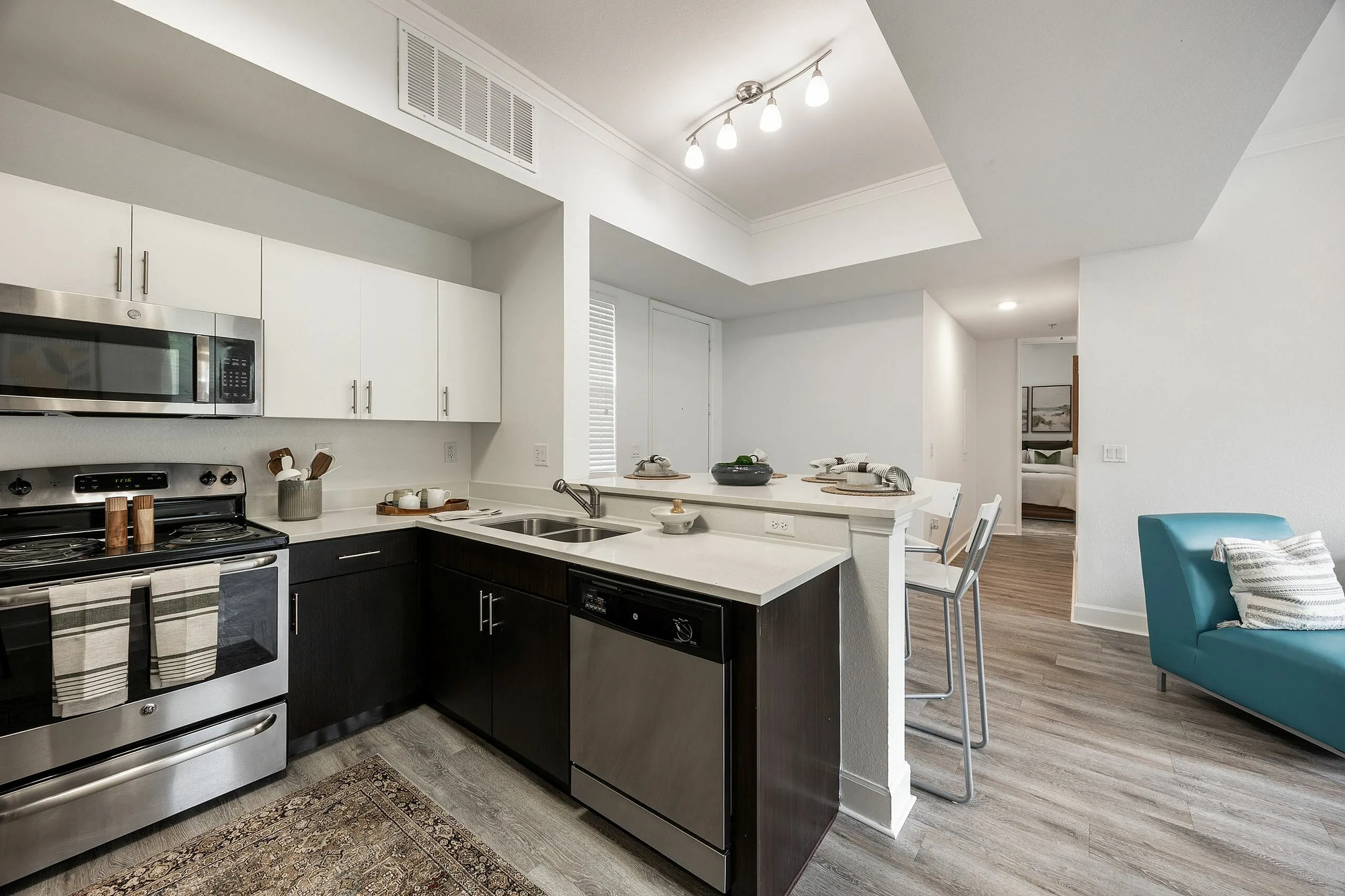 Modern open kitchen design with stainless steel appliances, elegant dining area, and cozy seating, exuding contemporary charm and style.