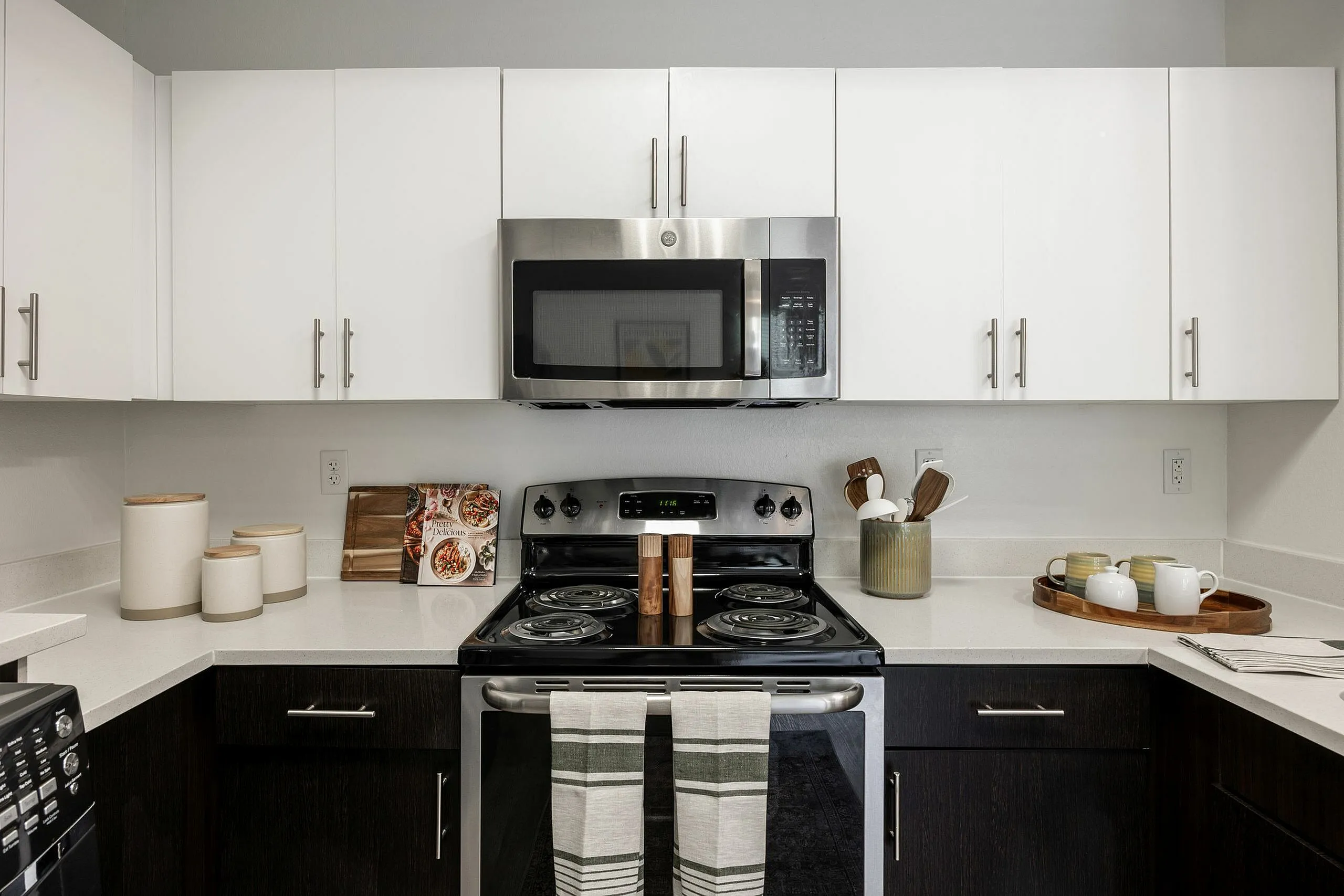 Modern kitchen with sleek white cabinets, stainless steel appliances, and stylish countertop decor.