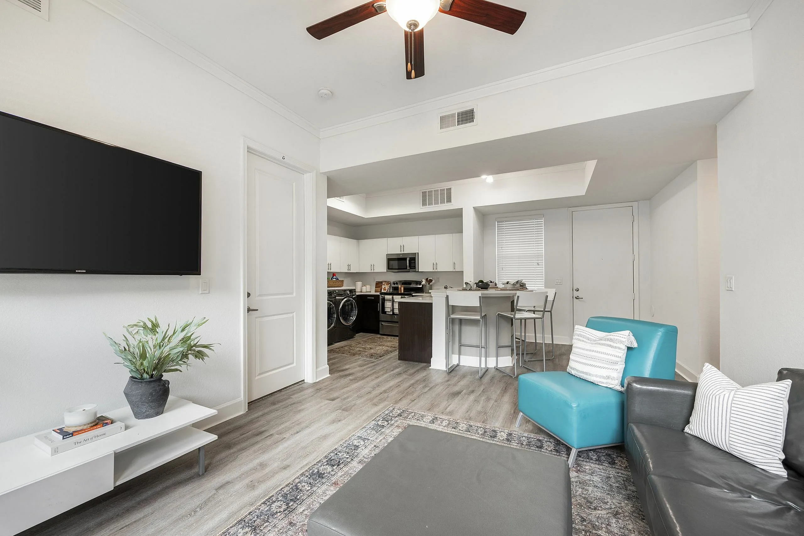 Modern open-concept living area with stylish furnishings, a sleek kitchen, and elegant decor, perfect for contemporary living.