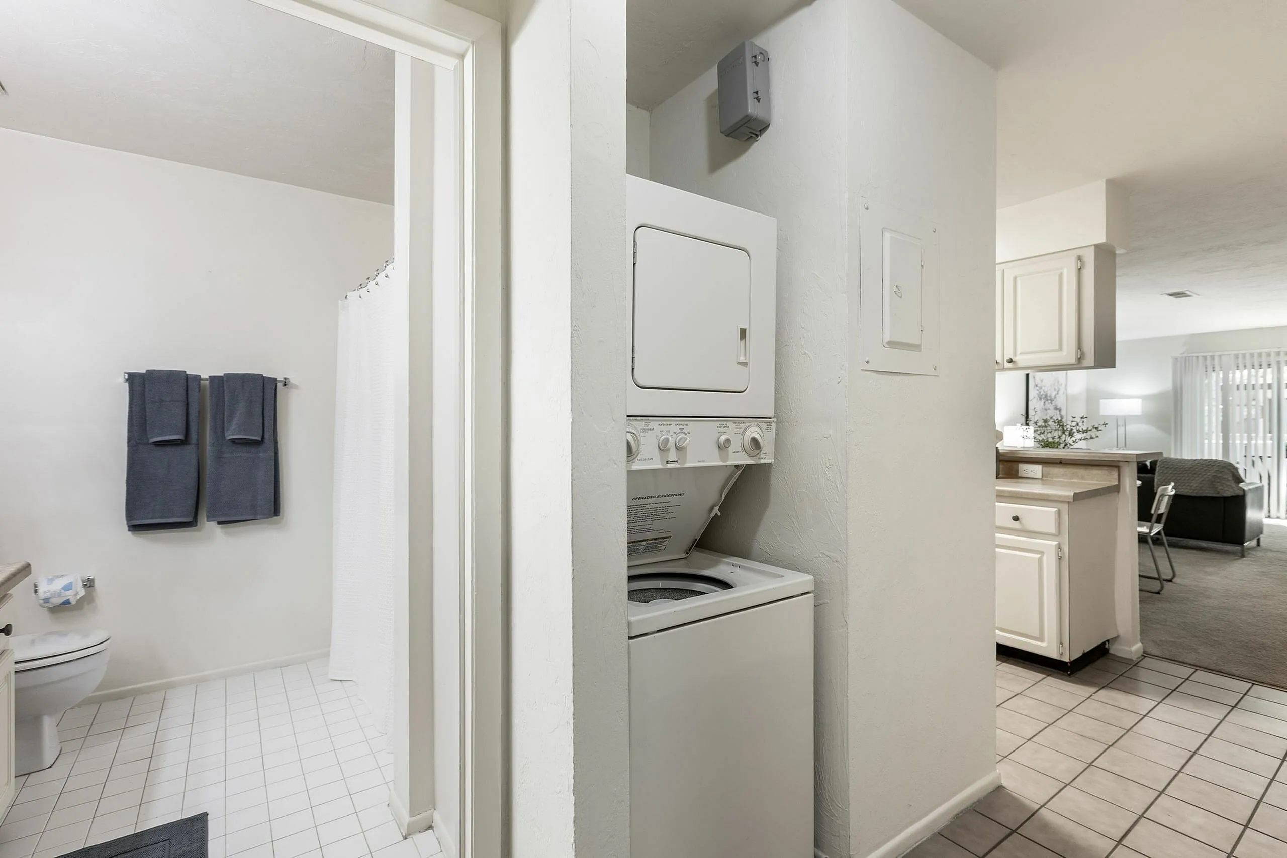 Modern apartment interior showcasing a bright bathroom, convenient in-unit laundry, and inviting open-plan living space.