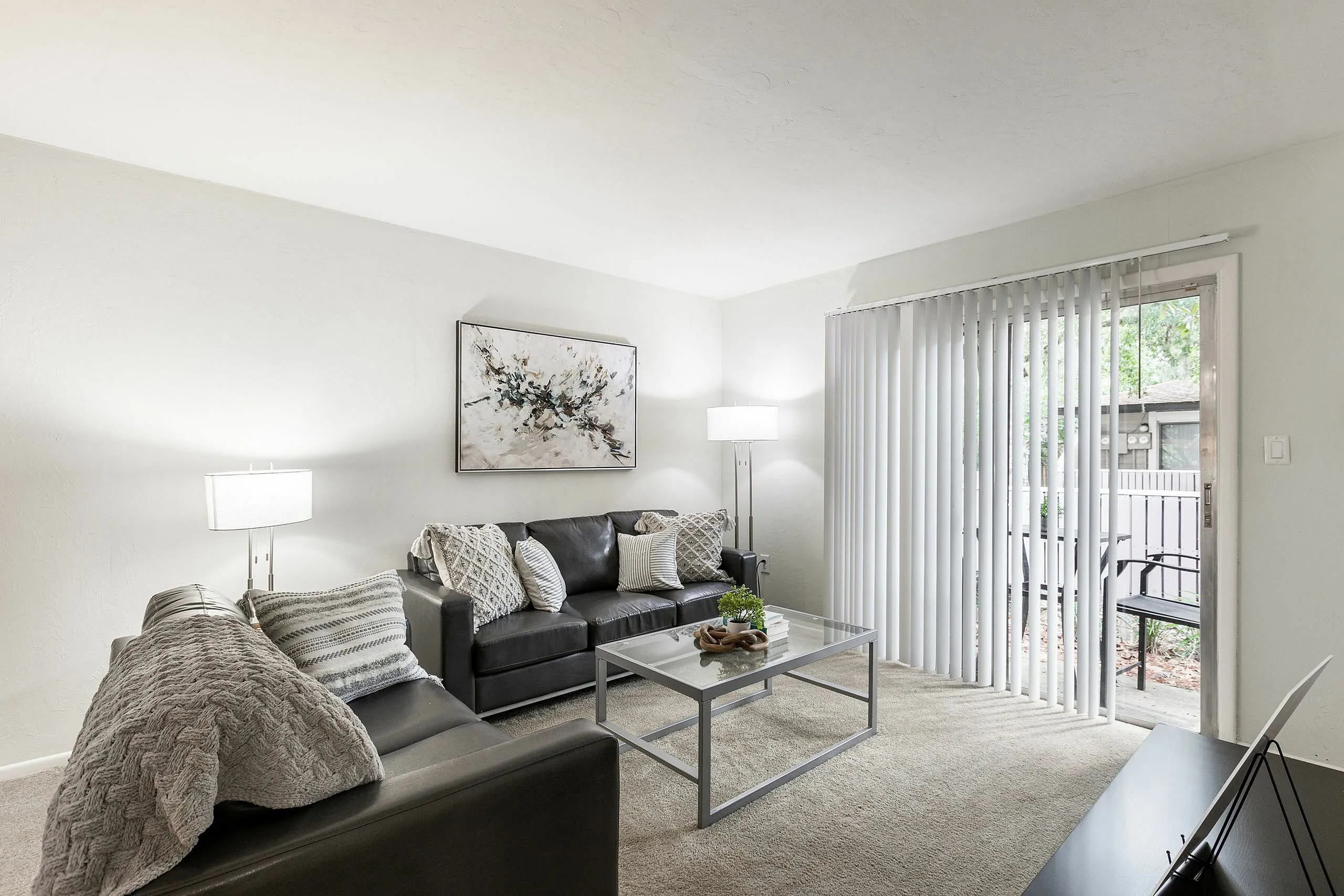 Inviting living room with sleek leather sofas, natural light from large sliding doors, and elegant decor.