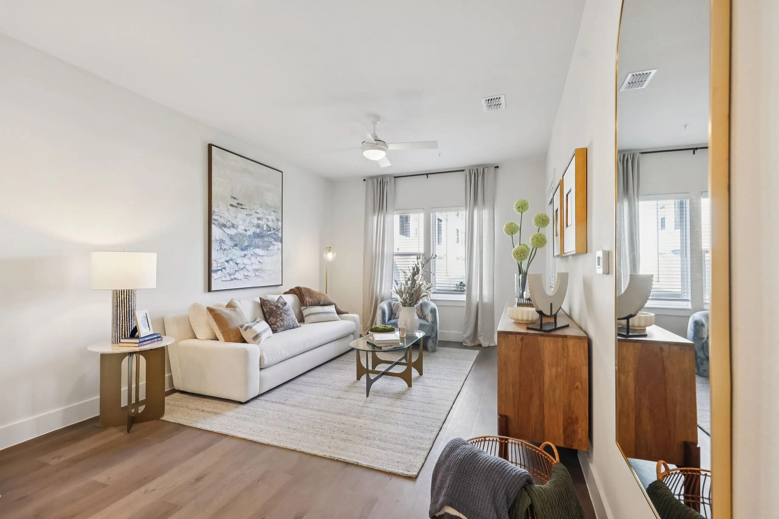 Elegant living room with modern decor, featuring a plush sofa, stylish art piece, and a chic coffee table with a bright atmosphere.