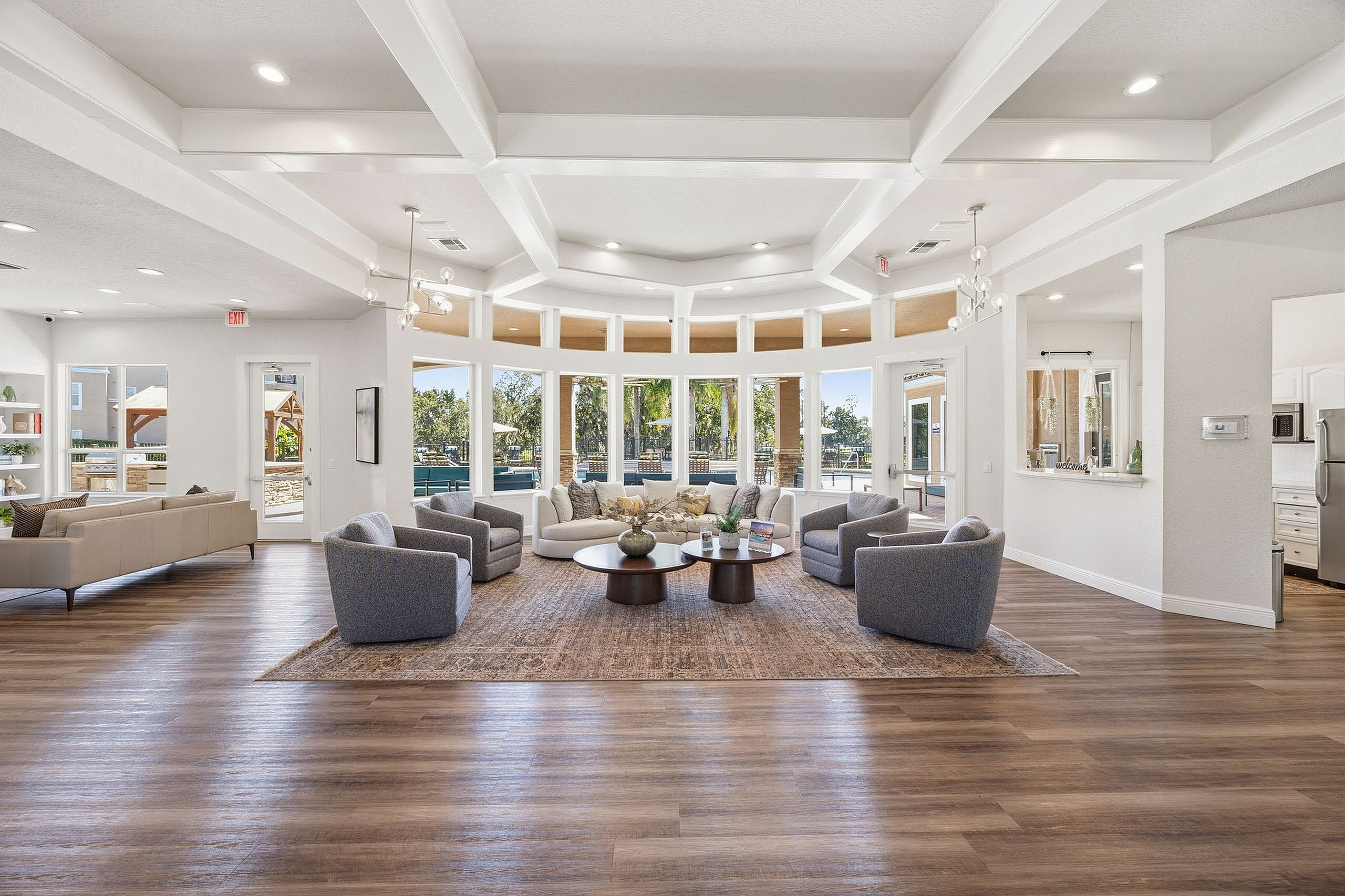 Bright and elegant living area with modern furnishings, wooden flooring, and large panoramic windows offering scenic views.