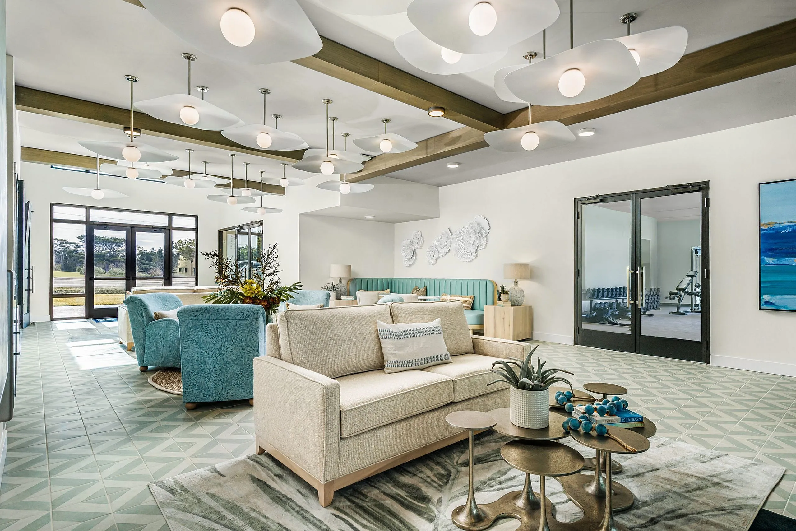 Elegant living space with modern decor, featuring plush seating, stylish lighting, and expansive windows offering serene views.