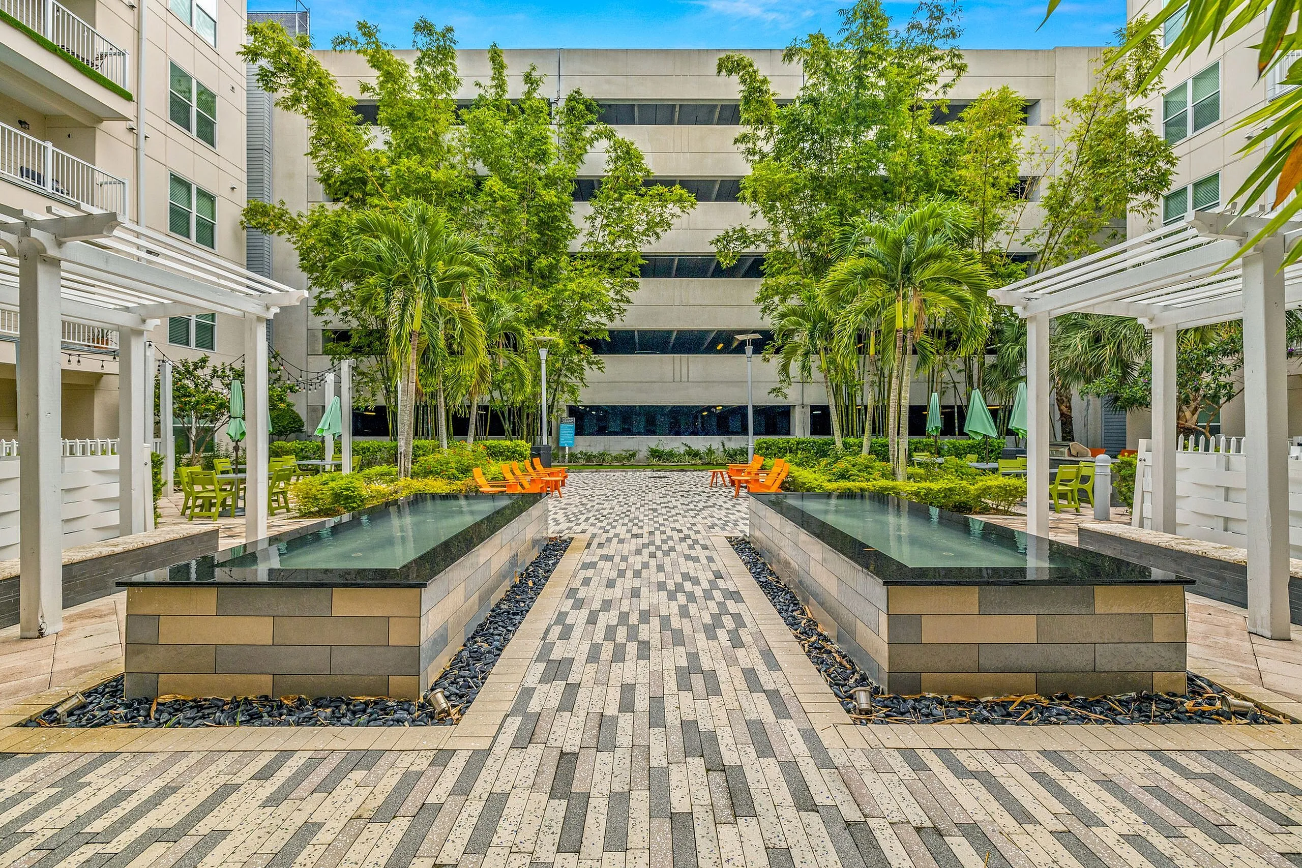 Elegant courtyard with modern water features, lush greenery, and comfortable seating, perfect for relaxation and gatherings.