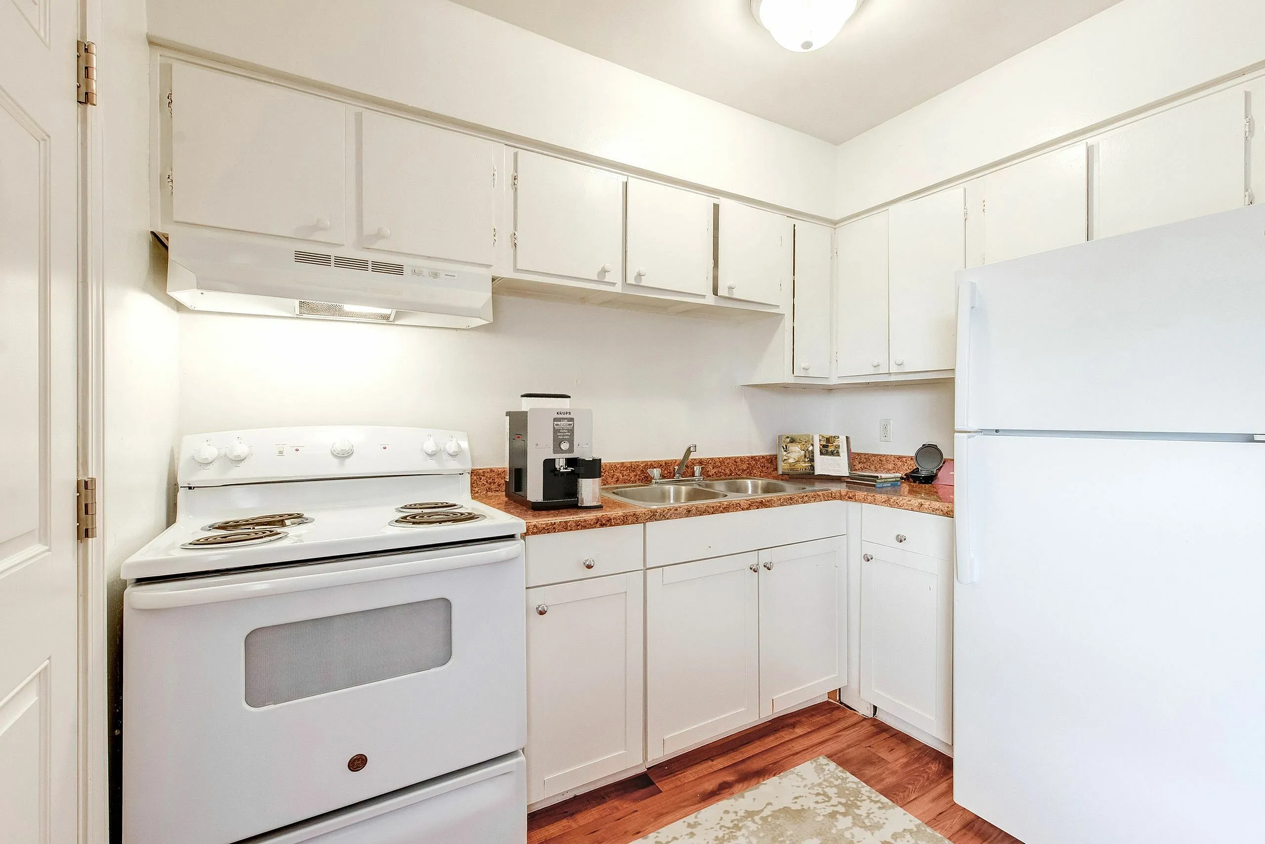 Bright and inviting kitchen with modern white cabinets, sleek countertop, and convenient appliances.