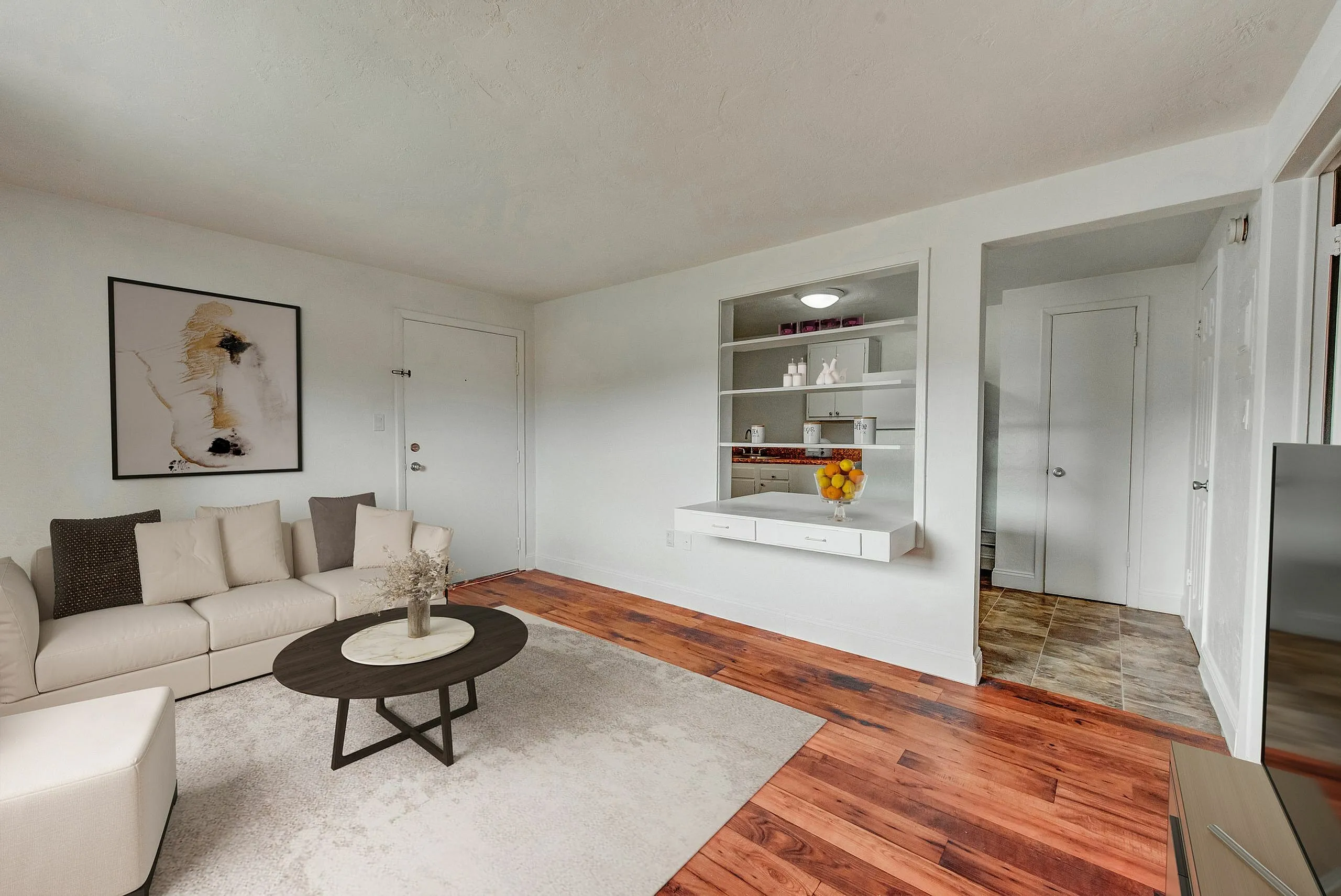 Inviting living room with modern decor, plush white sofa, and elegant wooden flooring, perfect for relaxation.
