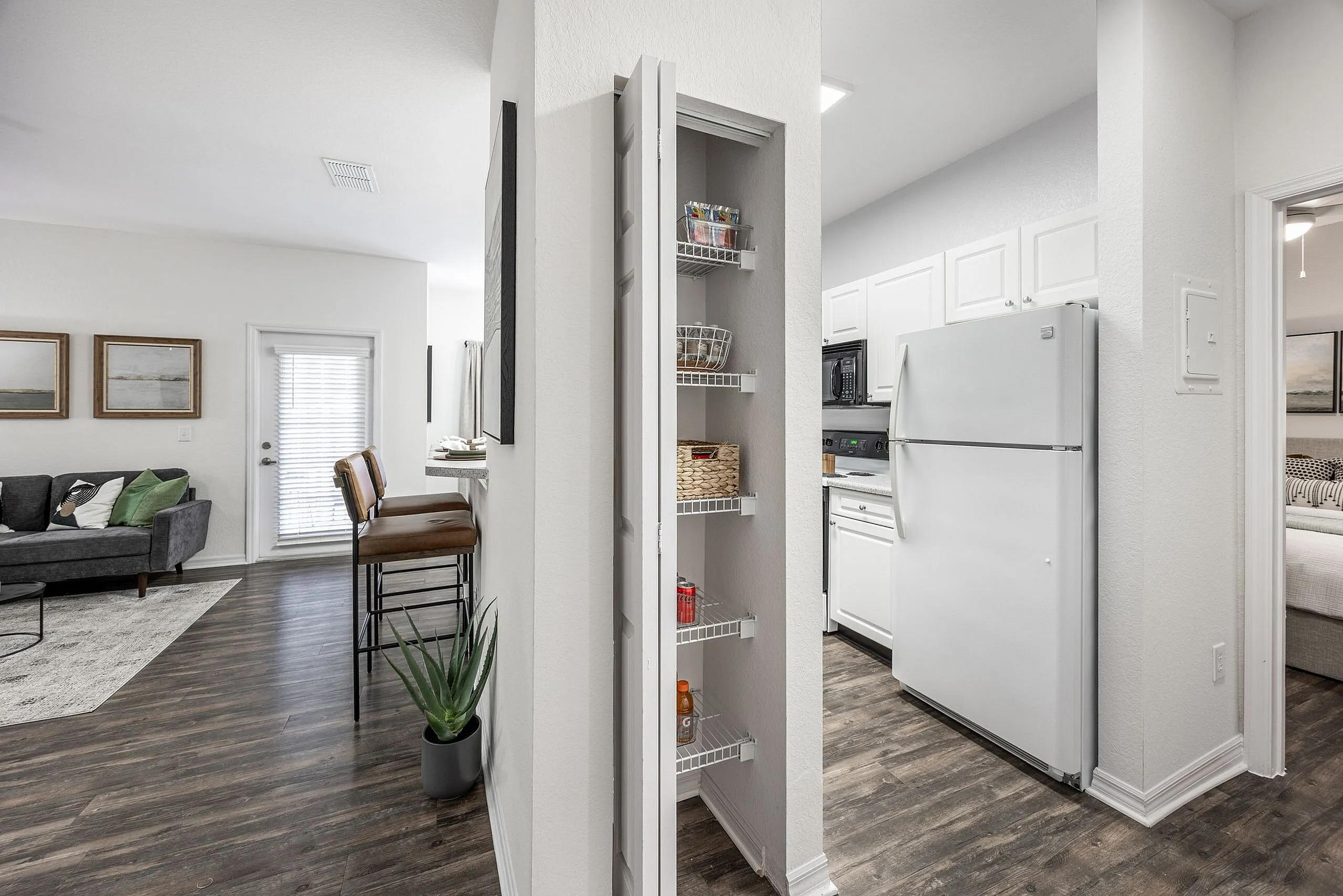 Bright and inviting apartment showcasing modern kitchen, cozy living room with stylish decor, and sleek hardwood floors.