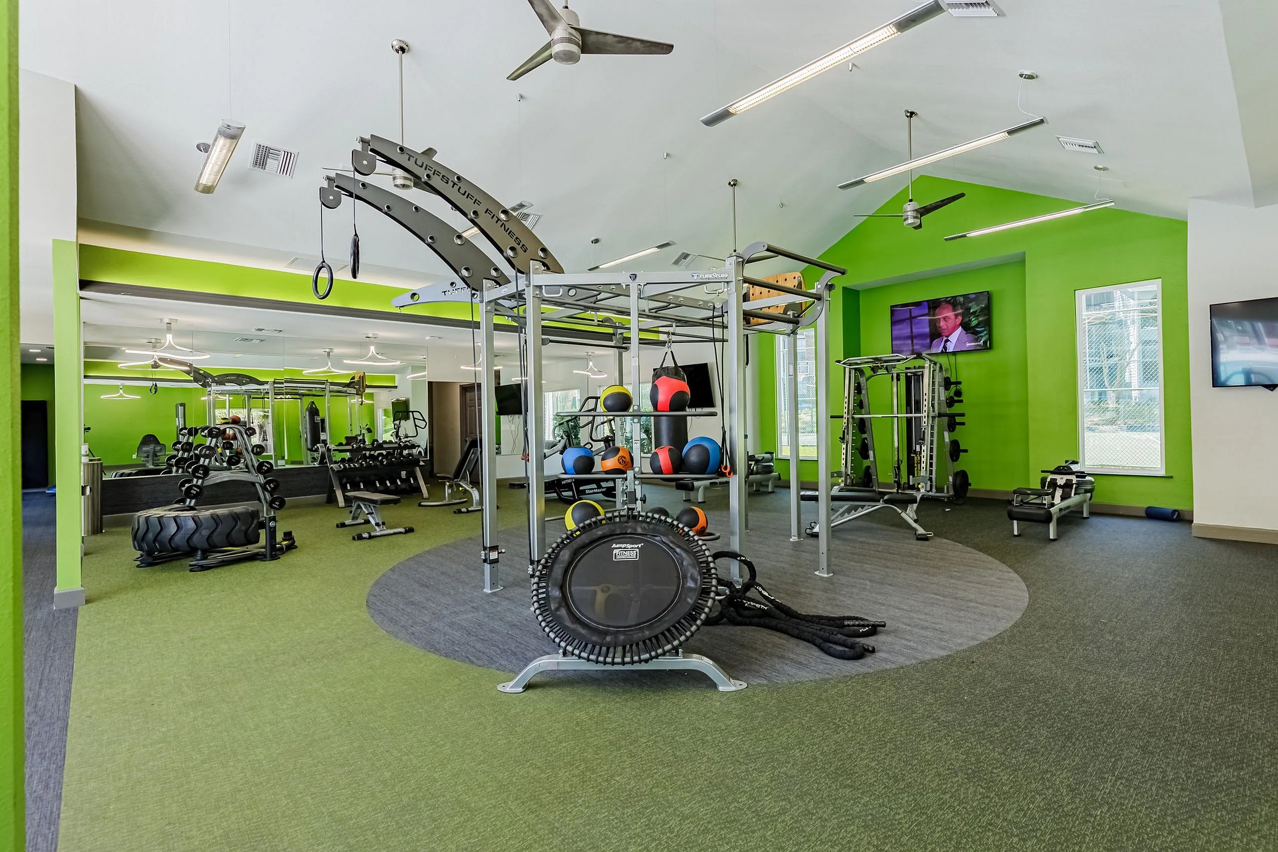 Modern gym with vibrant green accents, equipped with advanced fitness machines, free weights, and ample space for dynamic workouts.