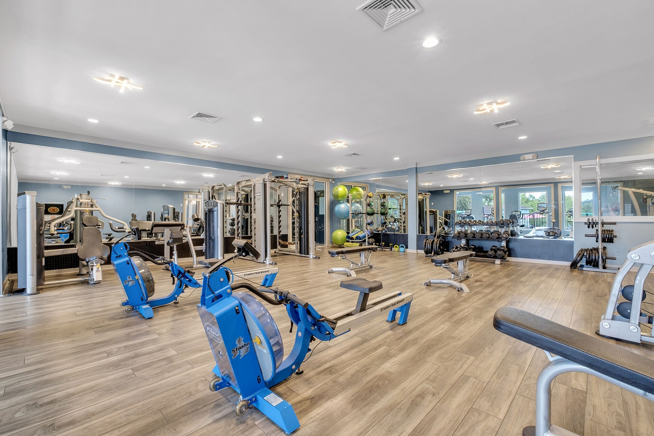 Spacious and modern fitness center with state-of-the-art equipment and vibrant natural lighting.